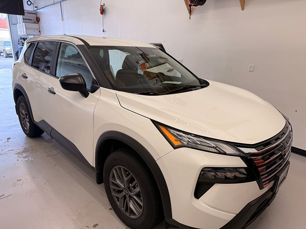 White Nissan Rogue SUV parked indoors.