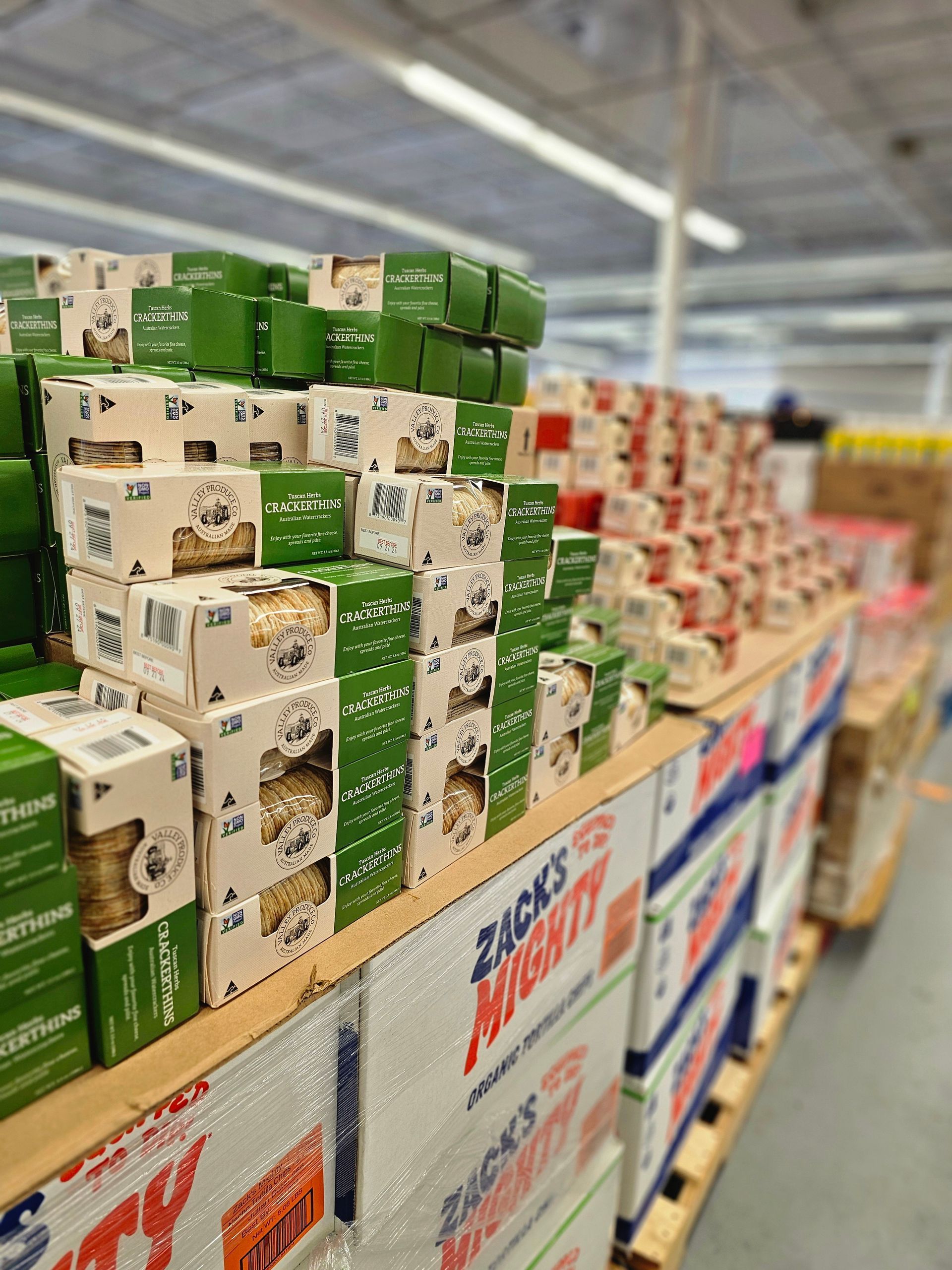 A grocery store aisle filled with boxes of snacks including zacky nut butter