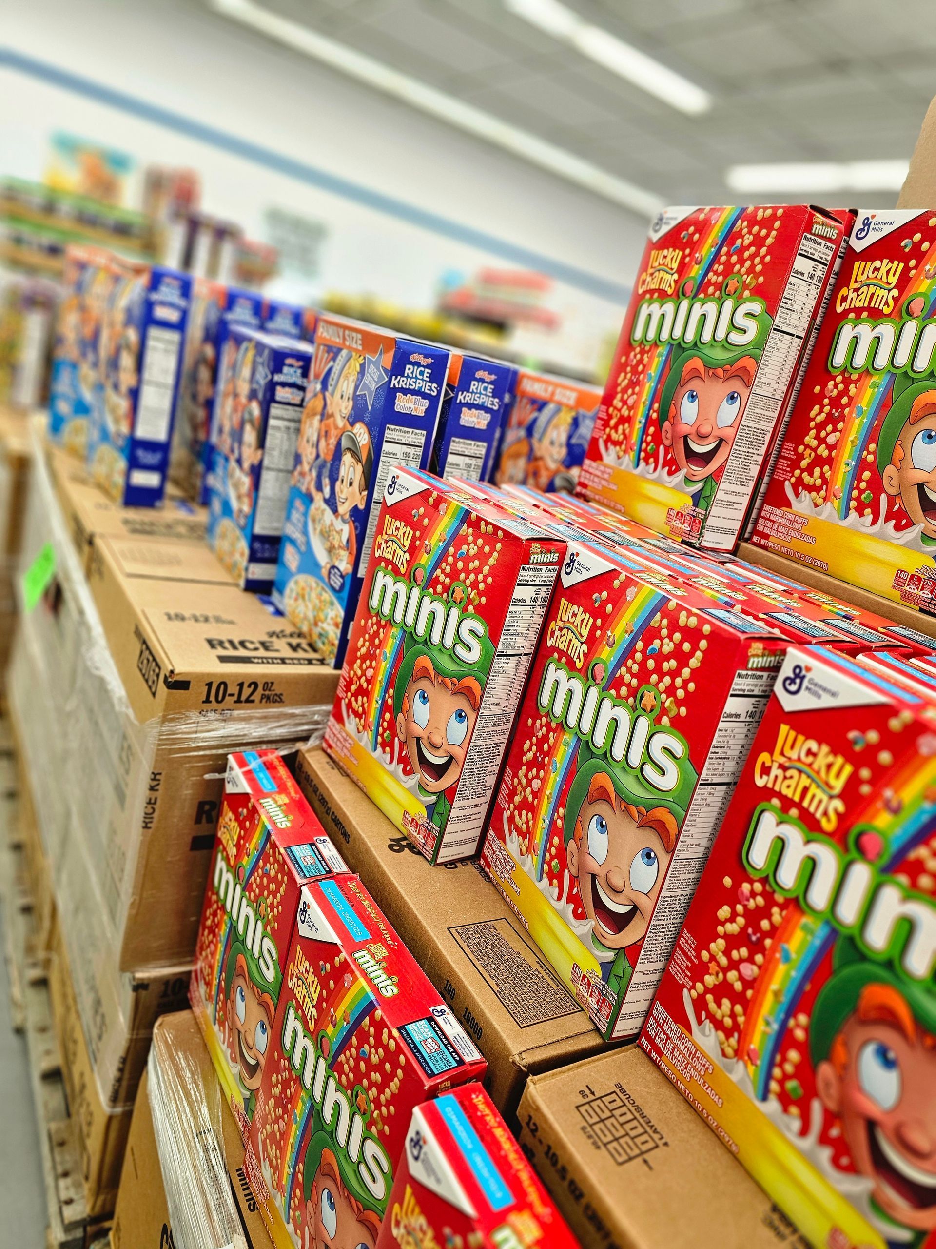 A row of boxes of kellogg 's minis cereal in a store.