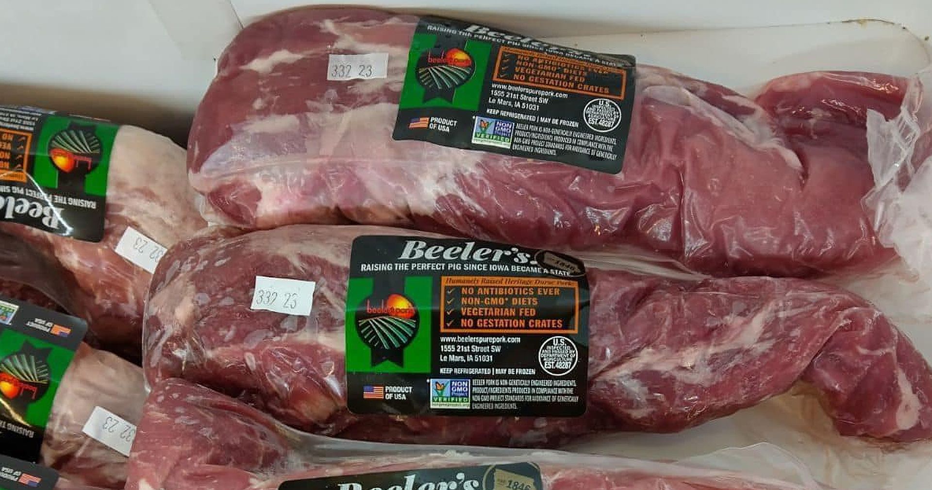 A box of meat with labels on it is sitting on a table.