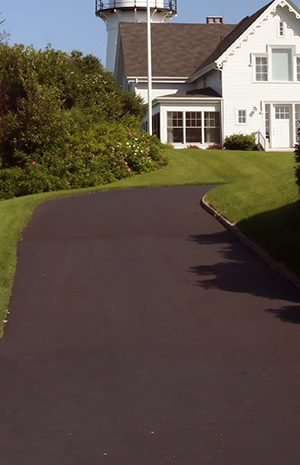A asphalt road connect to a house