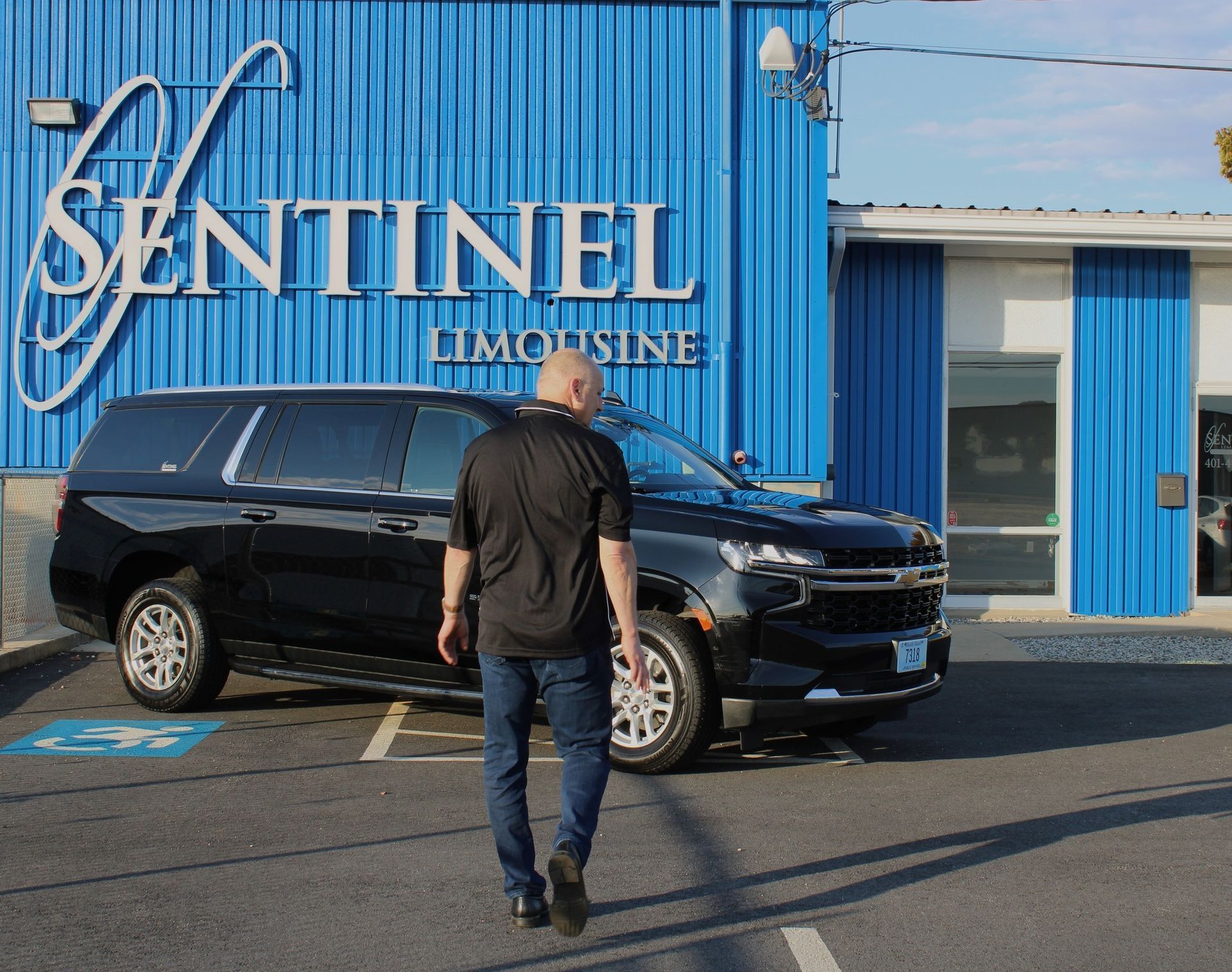 Man walks toward black SUV in front of 