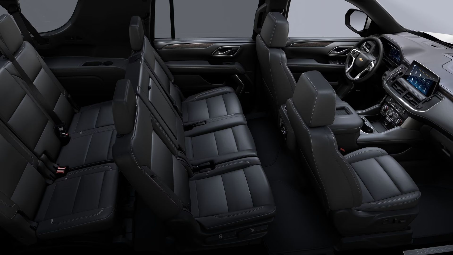 Black interior of a Chevrolet SUV with three rows of seats.