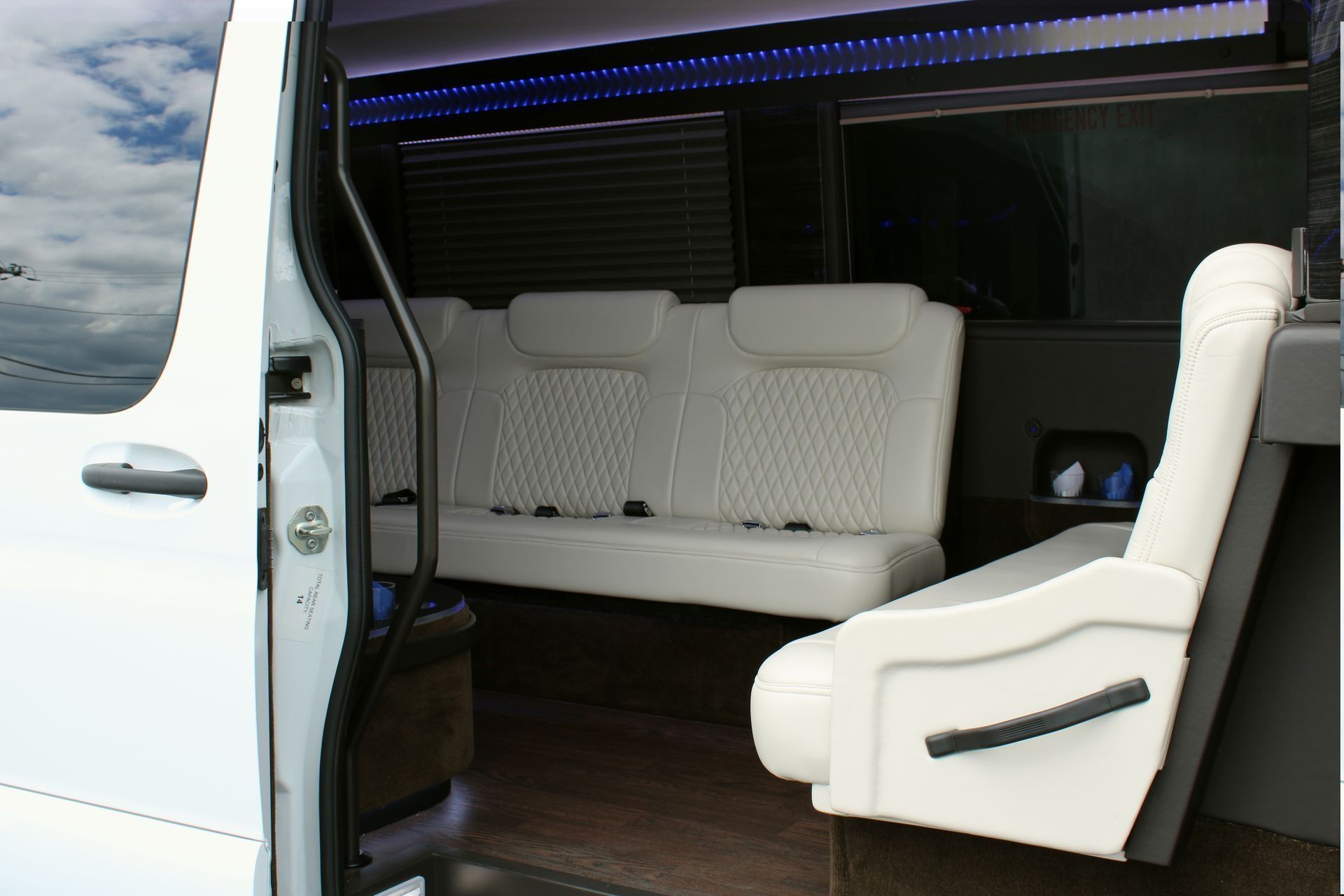 White van interior with white seating and wooden flooring.