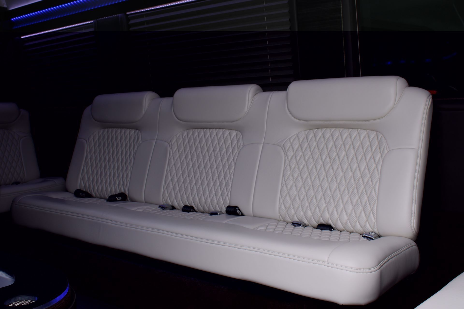 White leather passenger van seating with diamond stitching.