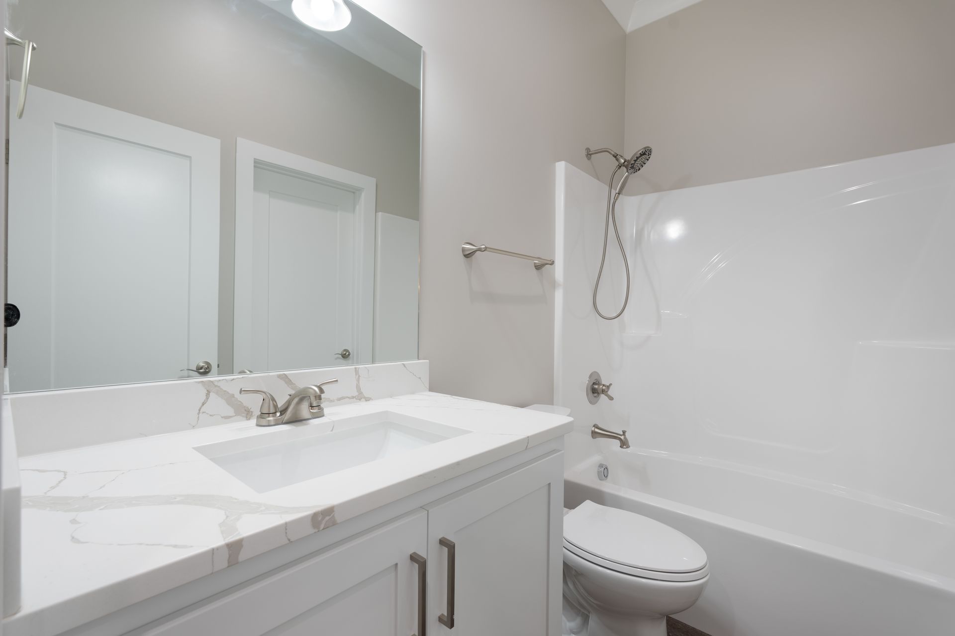 Bright white bathroom with vanity, mirror, sink, toilet, and bathtub with shower curtain rod
