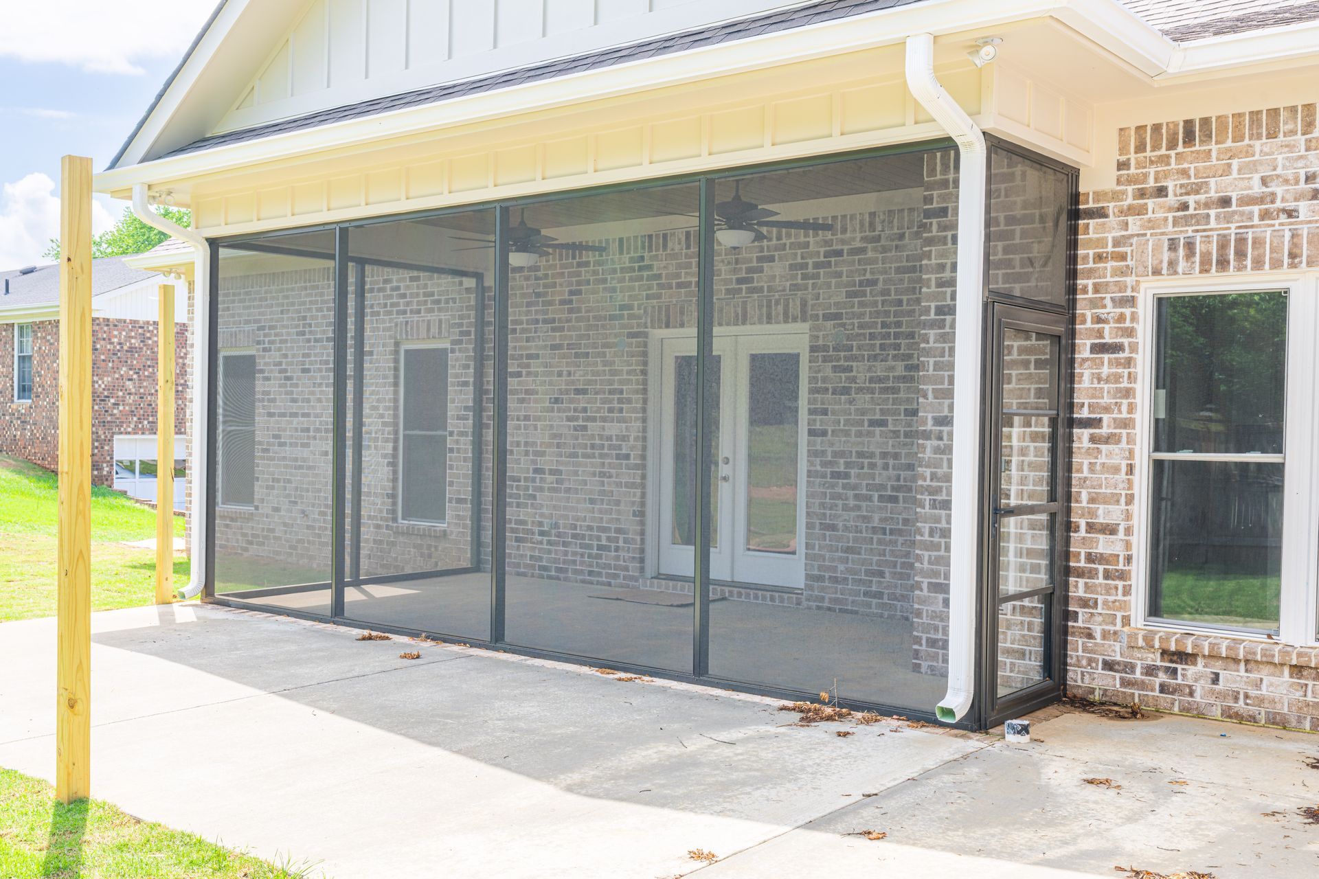 Covered brick patio with screened-in porch and double glass doors