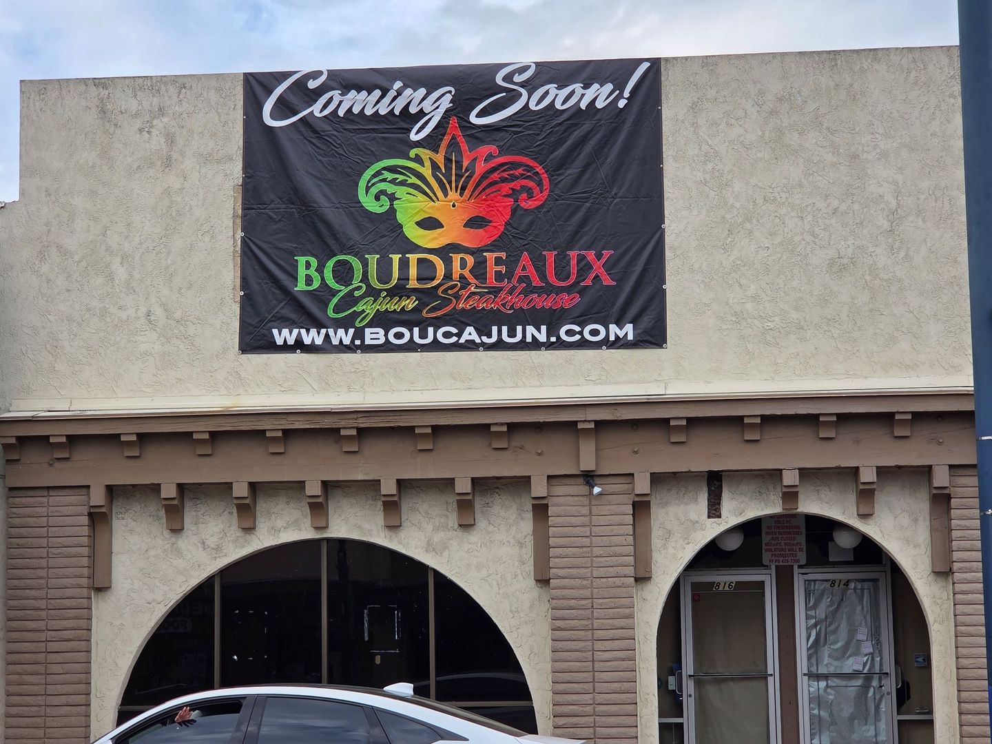 A sign on the side of a building that says coming soon