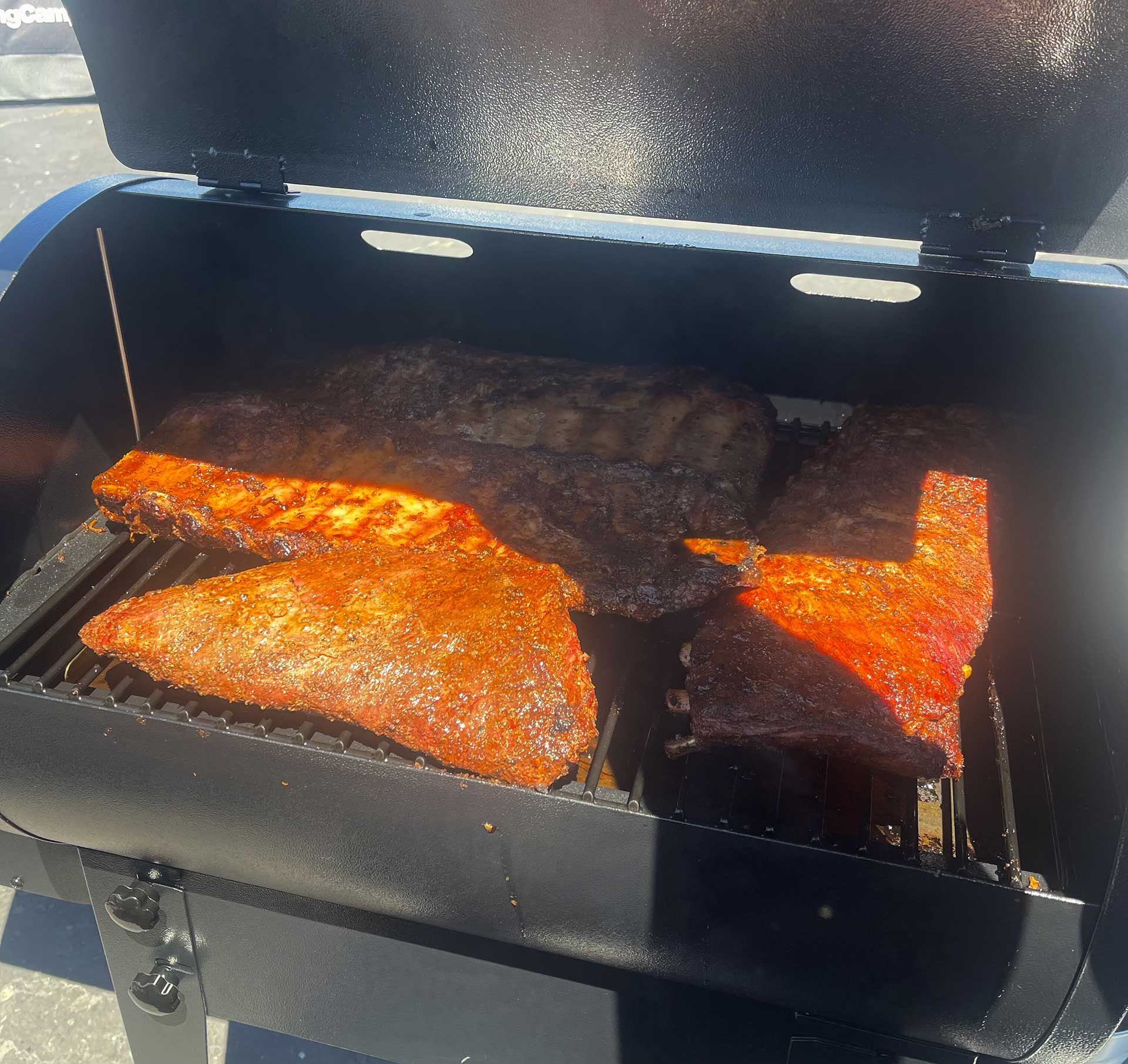 Three pieces of meat are getting cooked on a grill