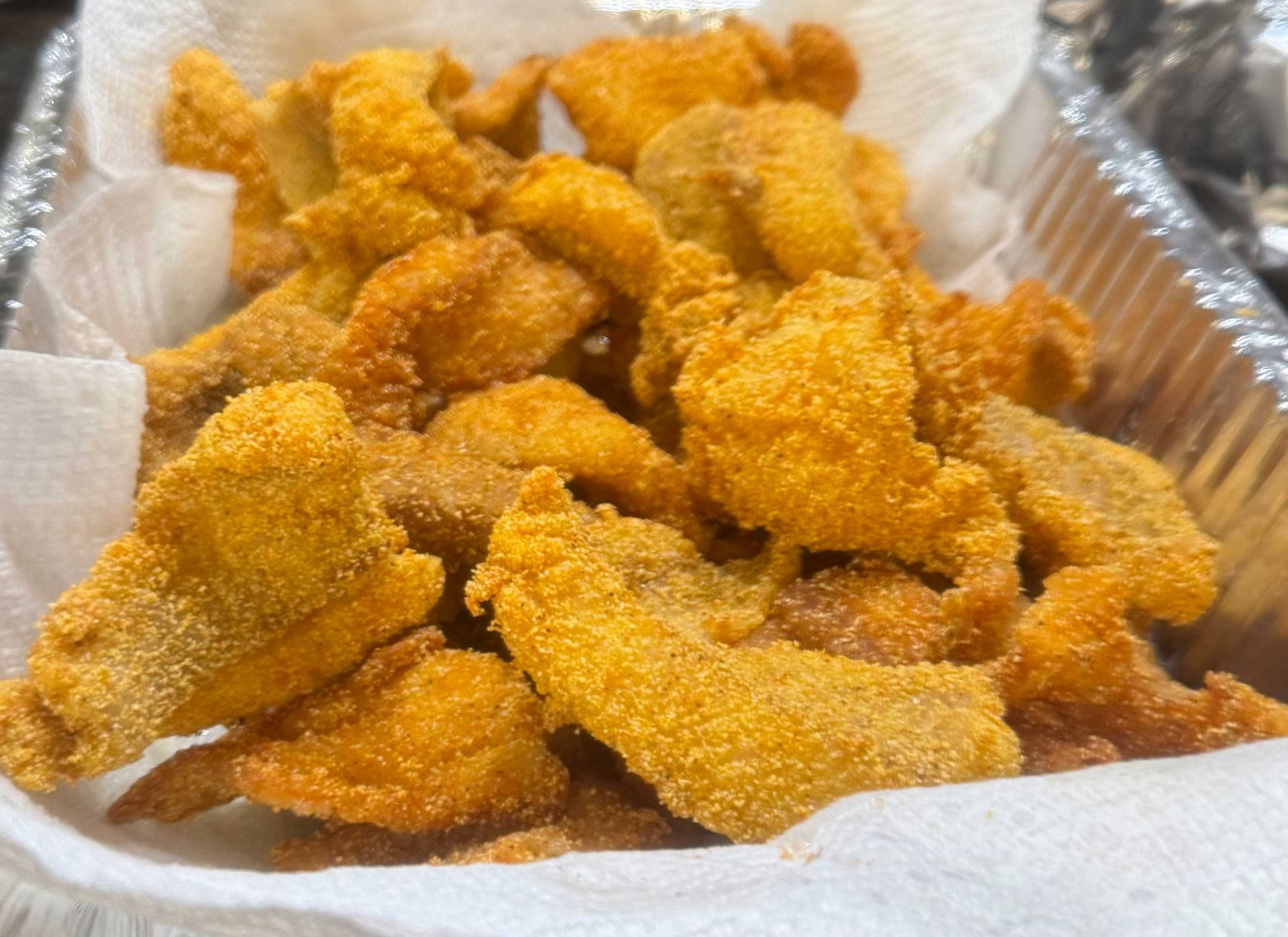 A close up of a basket of fried meat