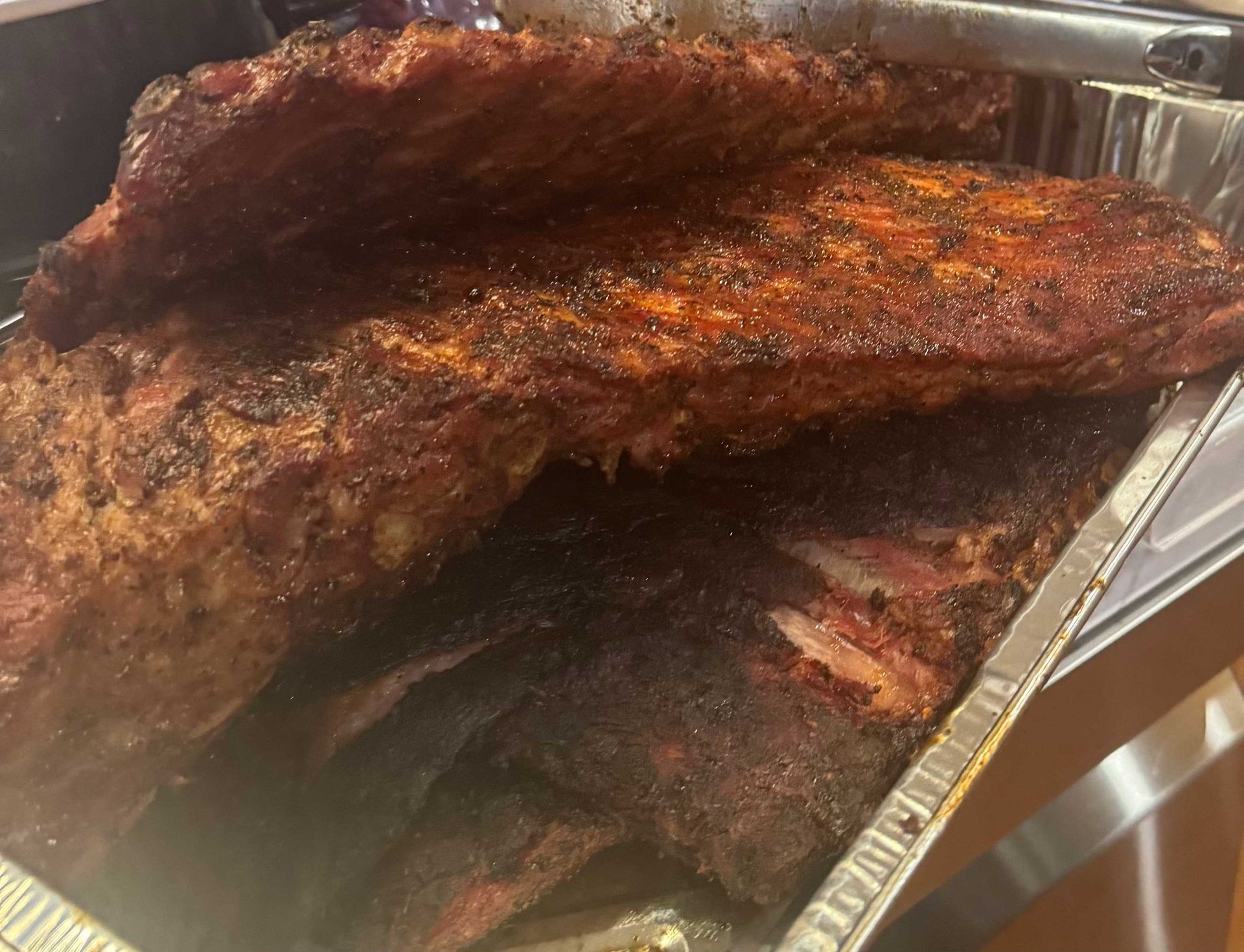 A tray of cooked ribs is sitting on a table