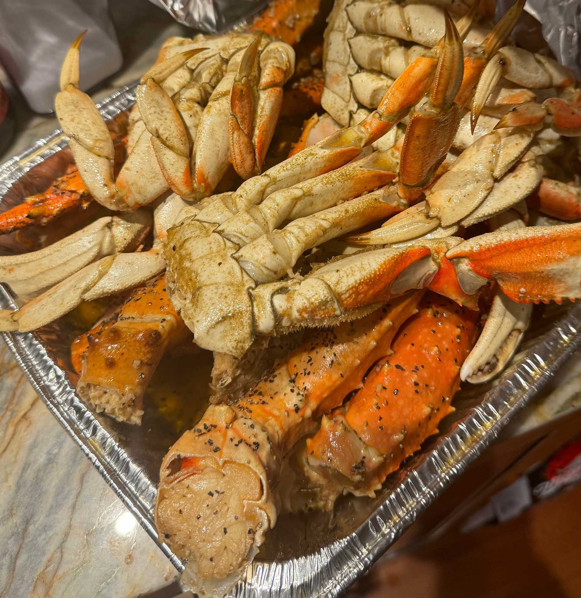 A tray of cooked Cajun crab legs on a table