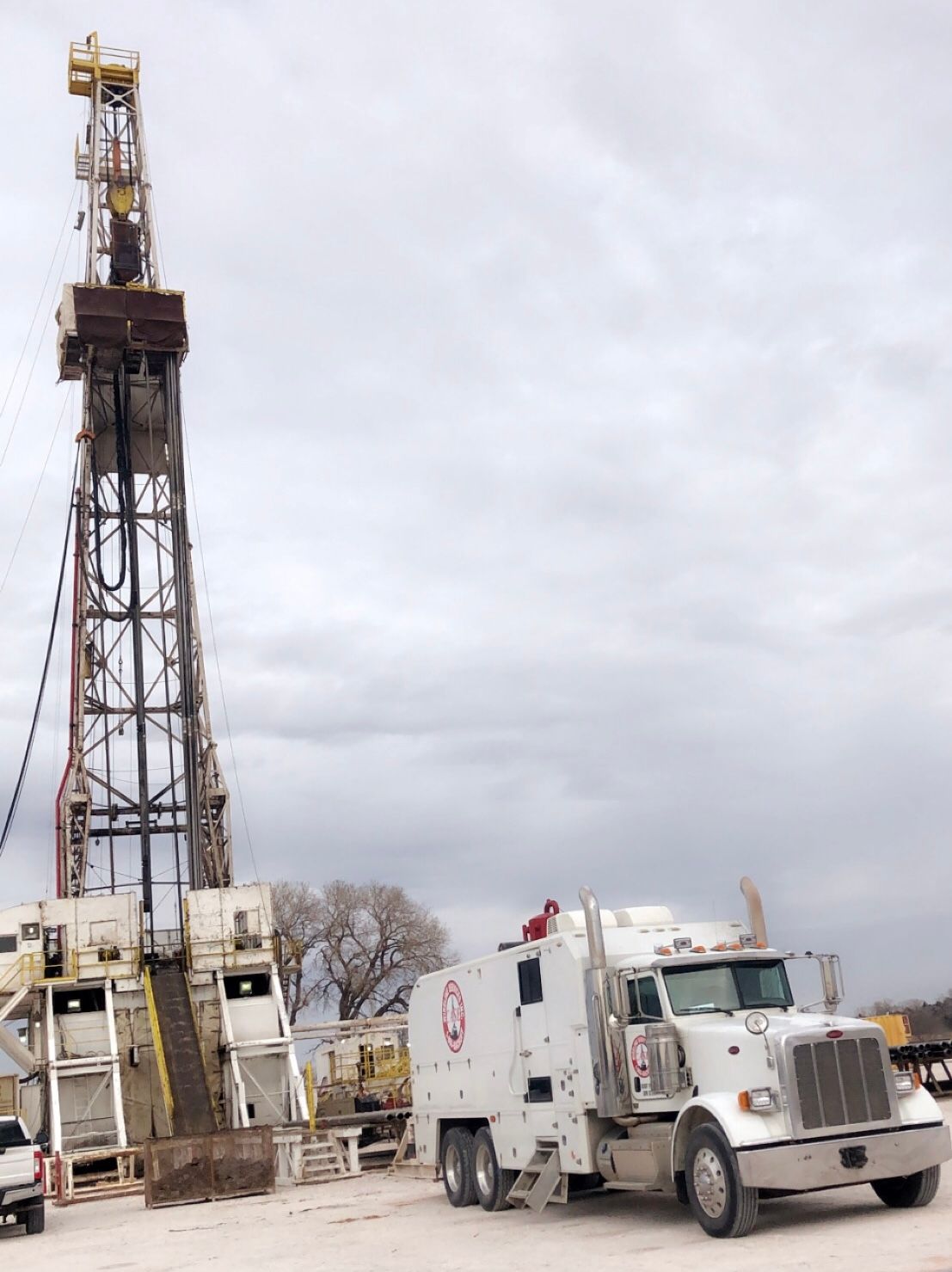 Oil rig with a large truck on a cloudy day.