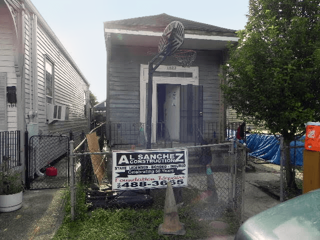 A sign on a fence says al sanchez construction.