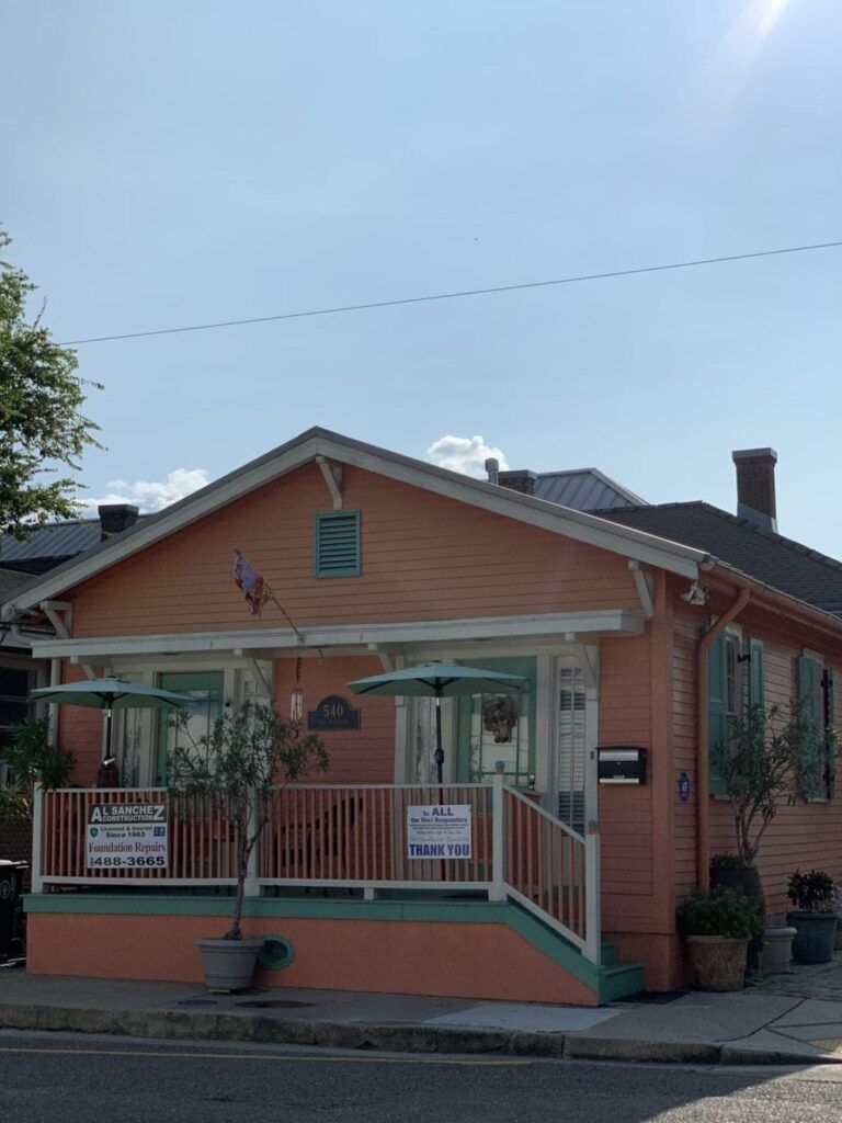 A small orange house with a porch and umbrellas.