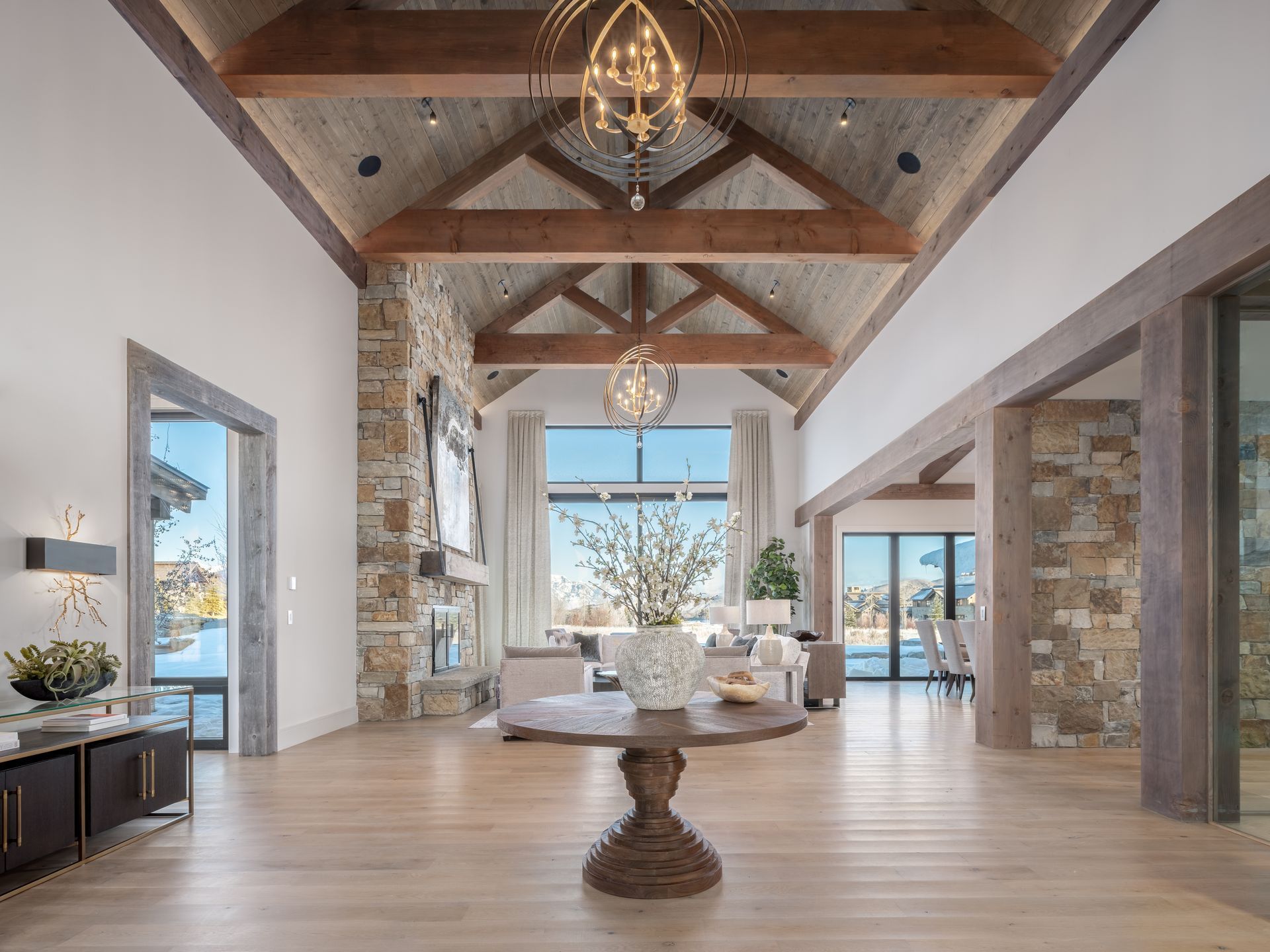 A large room with a table in the middle of it and a chandelier hanging from the ceiling.