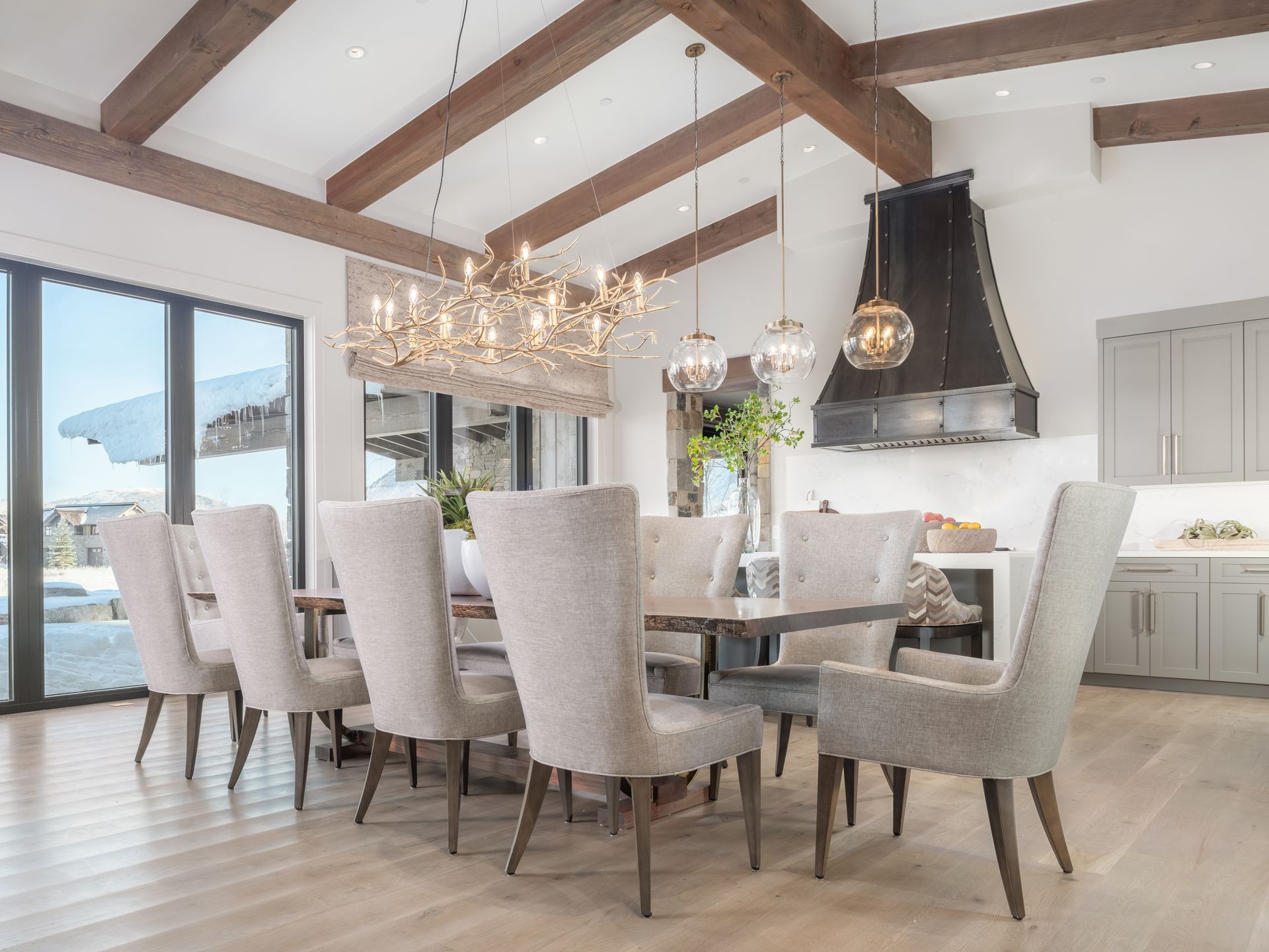 A dining room with a table and chairs and a chandelier hanging from the ceiling.