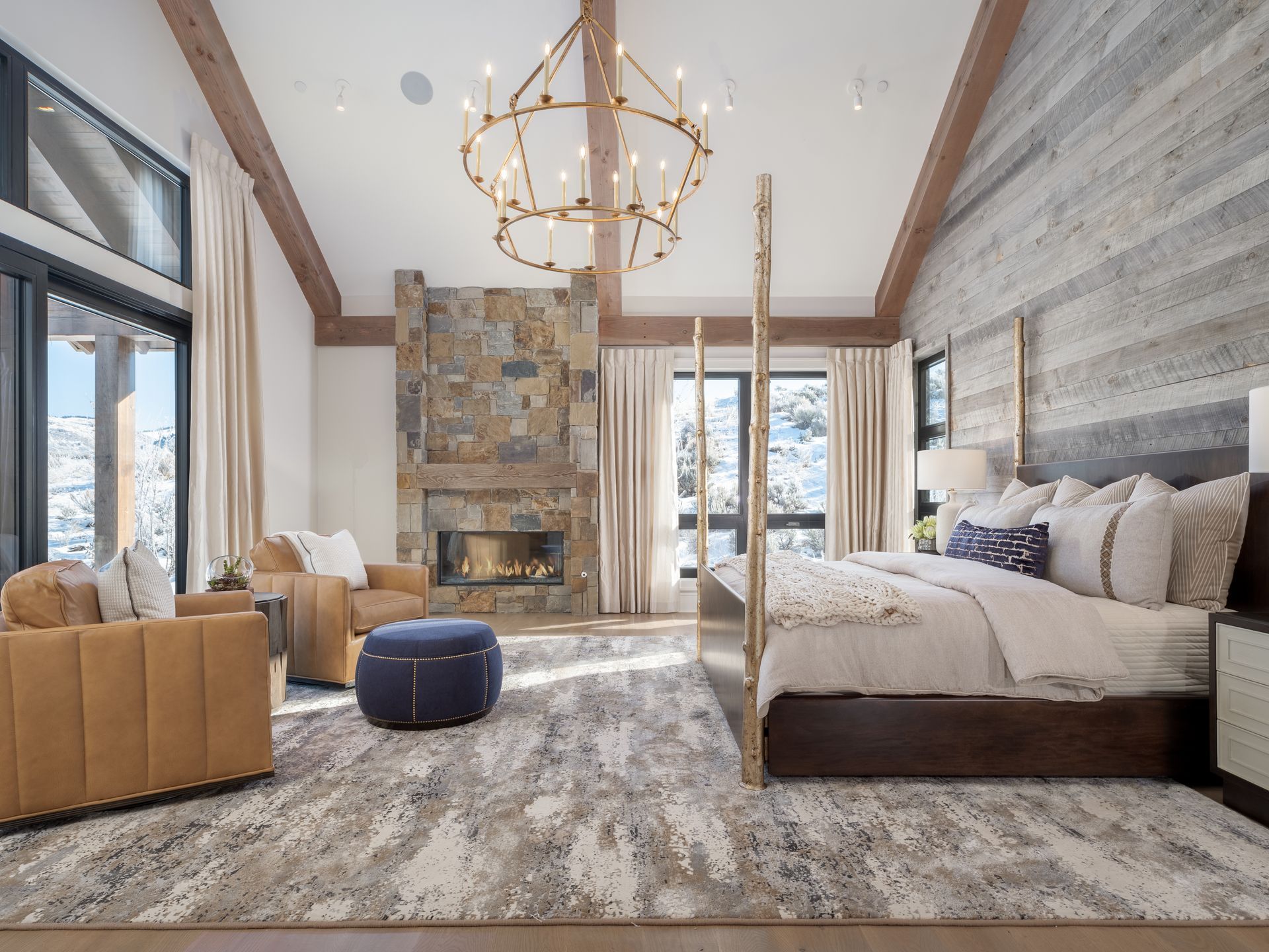 A bedroom with a bed , chairs , and a fireplace.