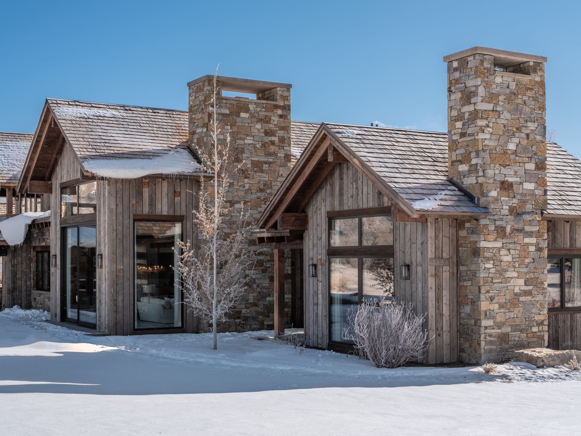 A large house with a lot of windows is covered in snow