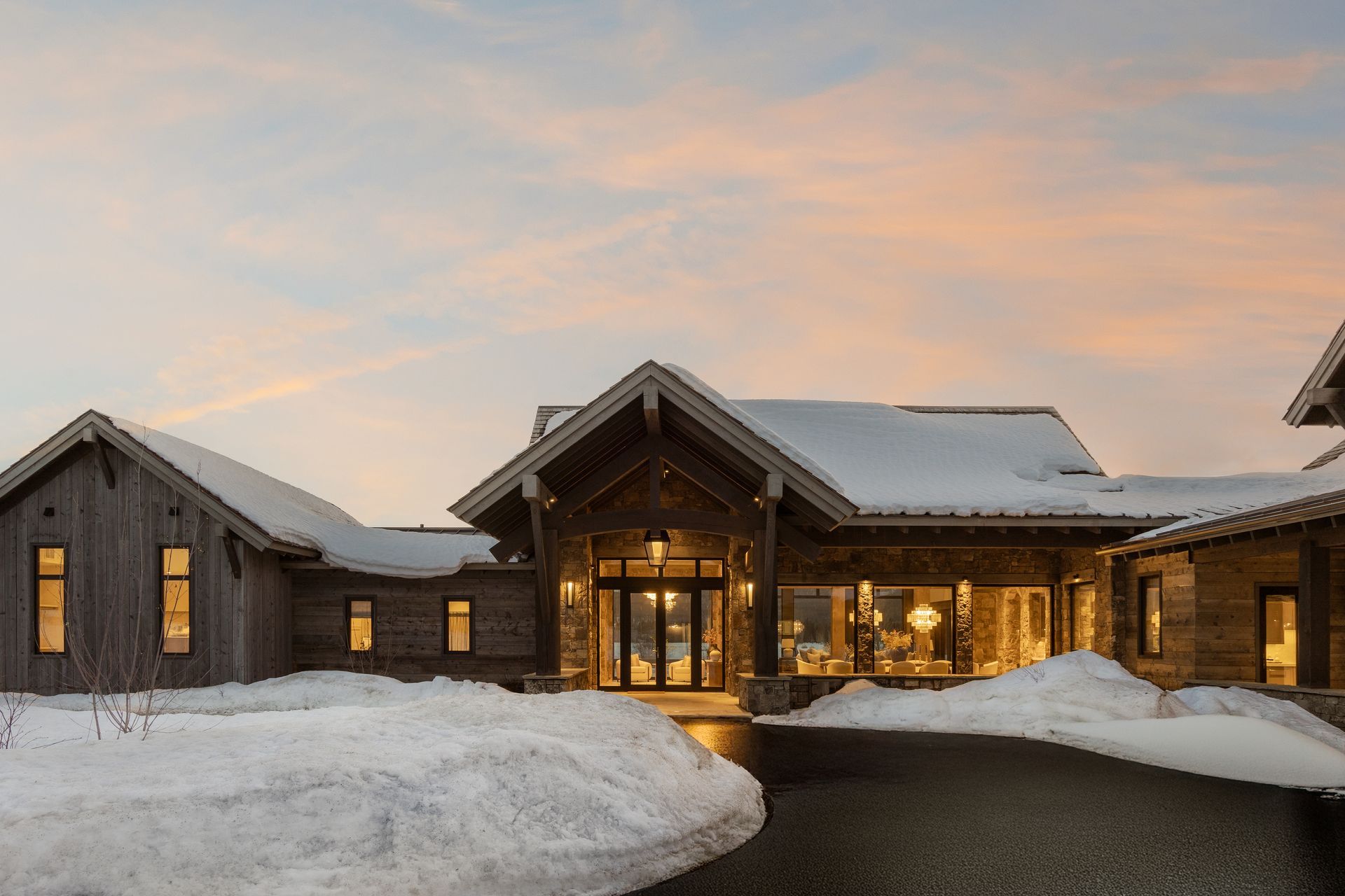 A large house with a lot of snow on the ground in front of it.