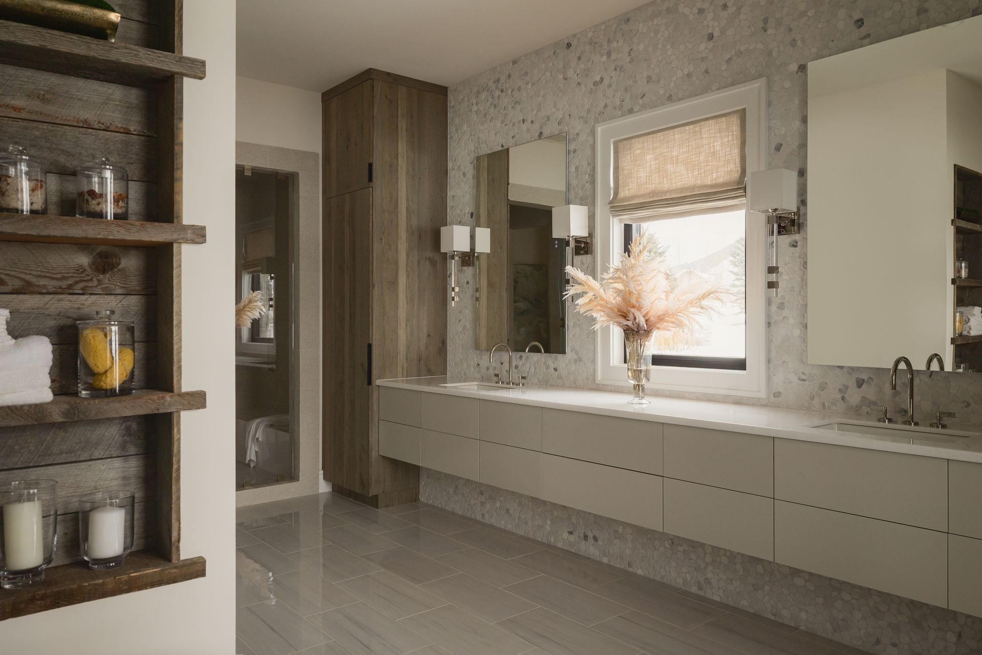 A bathroom with two sinks , two mirrors and a window.