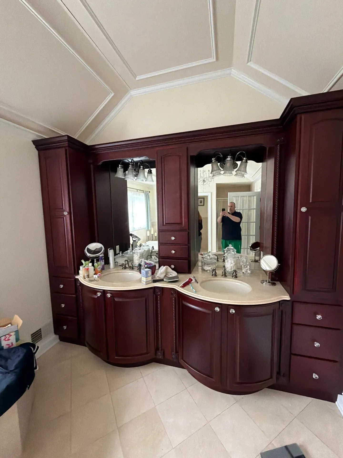 Double vanity bathroom with dark wood cabinetry, mirrors, and beige tile floor and ceiling.