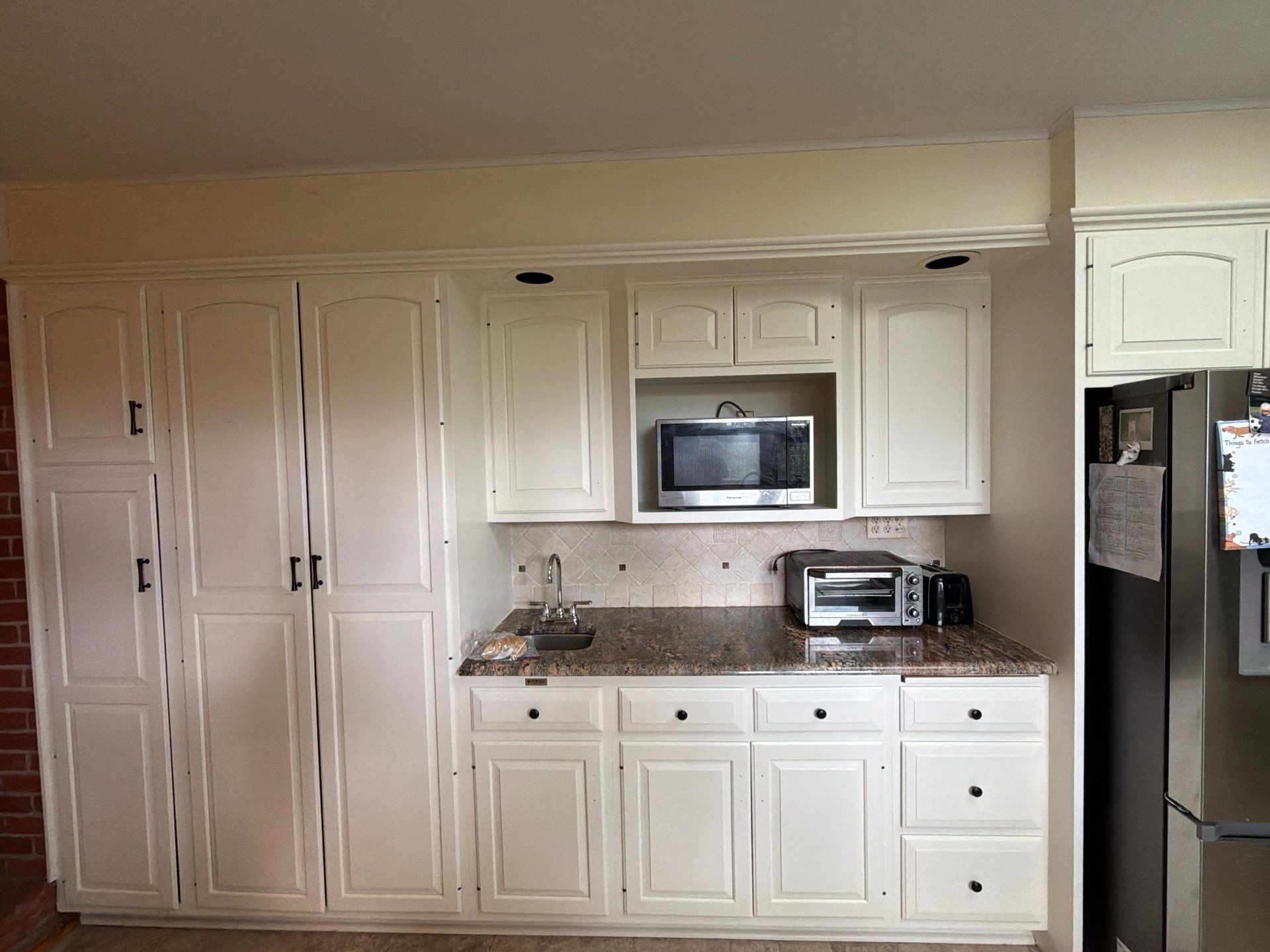 Kitchen with wood cabinets, granite countertop, and stainless steel fridge on the right.