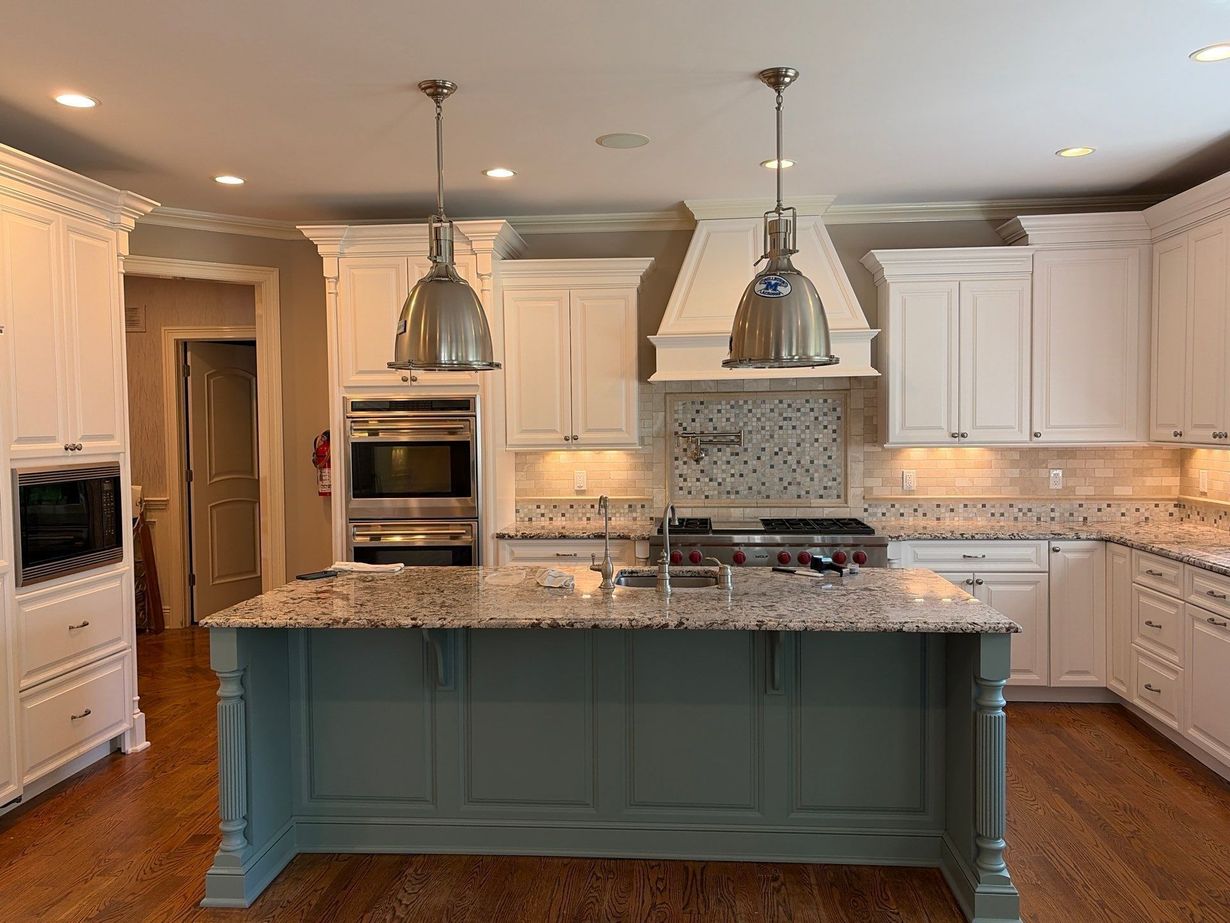 Modern kitchen with stainless steel appliances, gray cabinets, and white tile backsplash