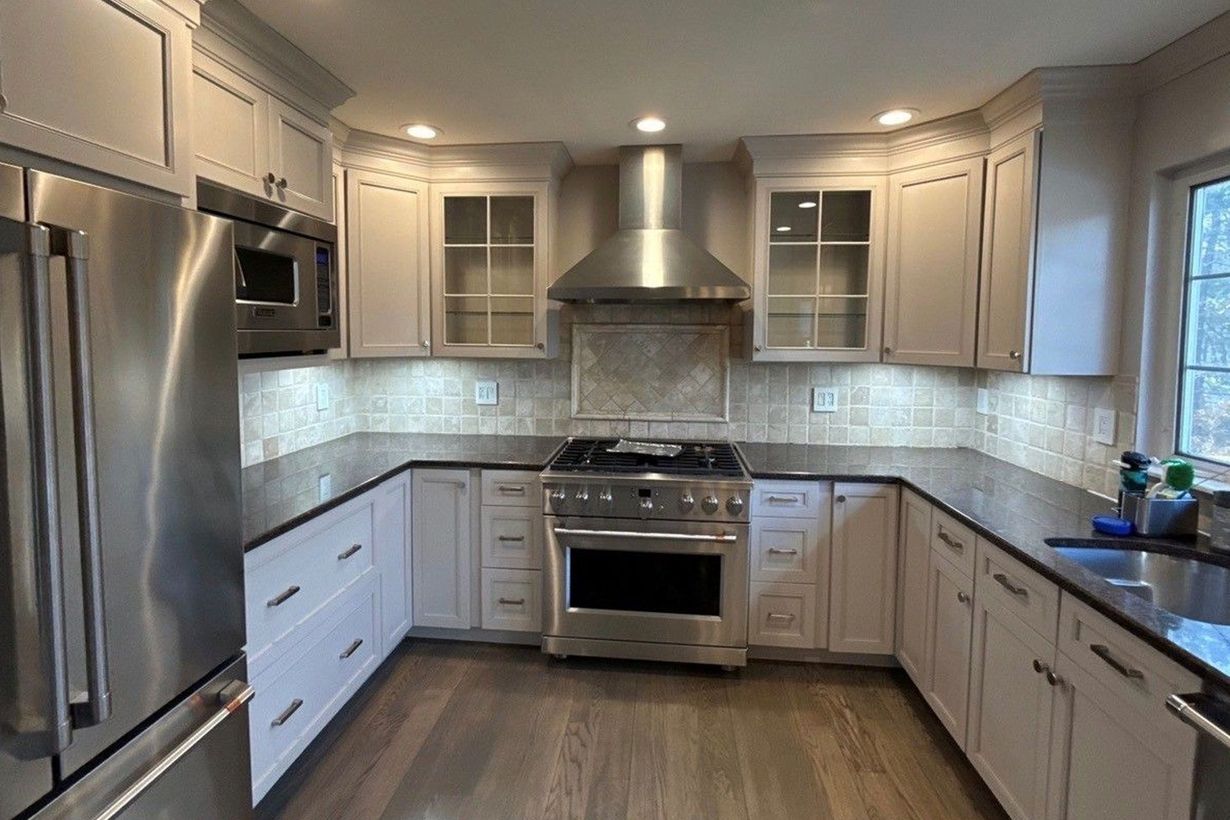 Modern kitchen with stainless steel appliances, gray cabinets, and white tile backsplash