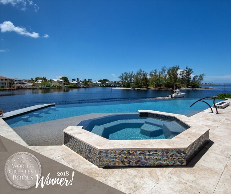 Luxury pool and spa with water views, blue water, and clear sky on a sunny day.
