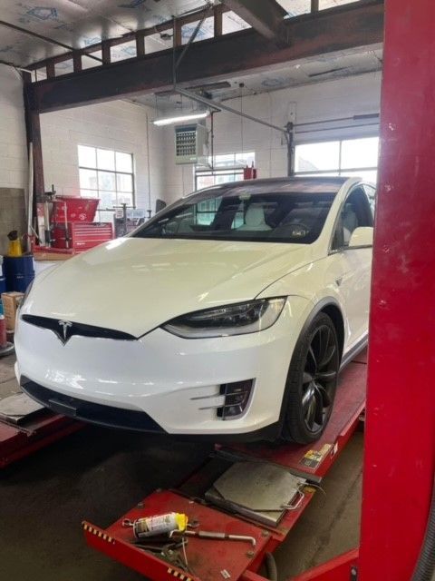 White car during the wheel alignment and tire rotation service