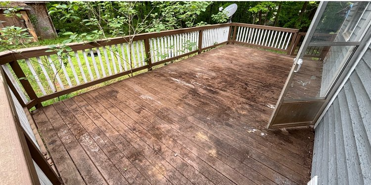 A wooden deck with a fence and a sliding glass door.