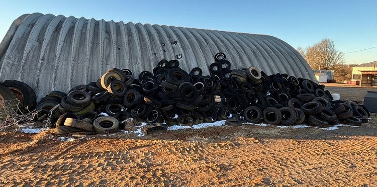 A pile of tires is sitting in front of a building.