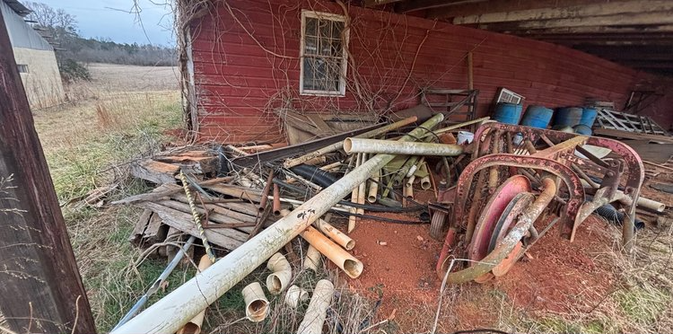 A pile of junk is sitting in front of a red brick building.