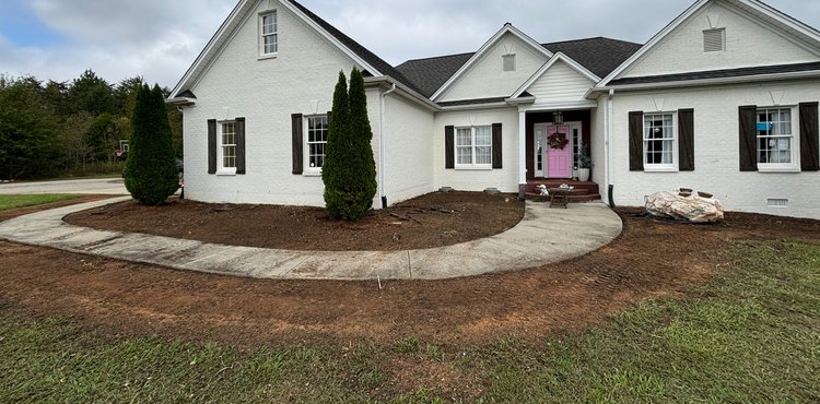 A white house with a pink door and a walkway leading to it.
