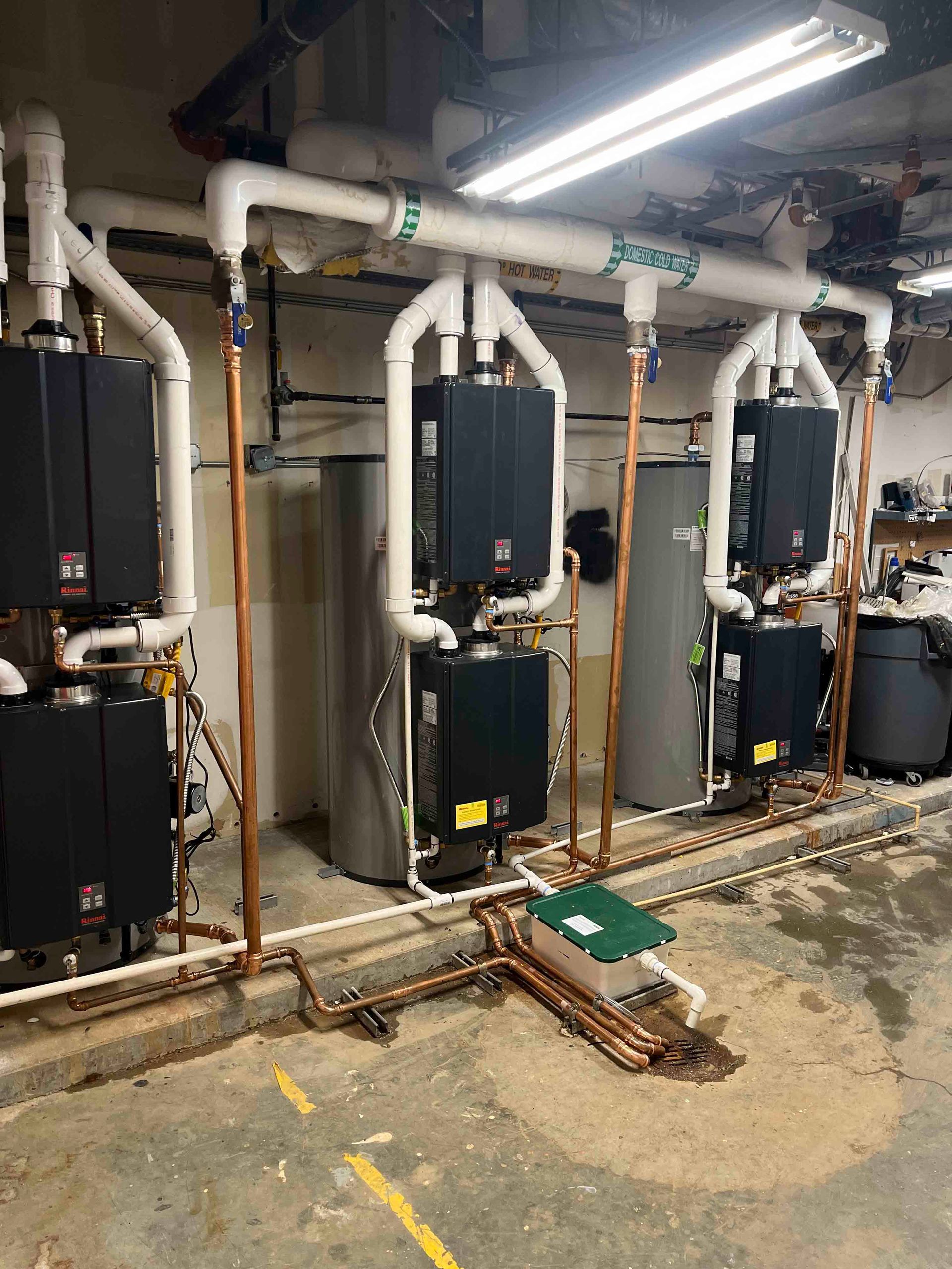A row of water heaters are sitting next to each other in a room.