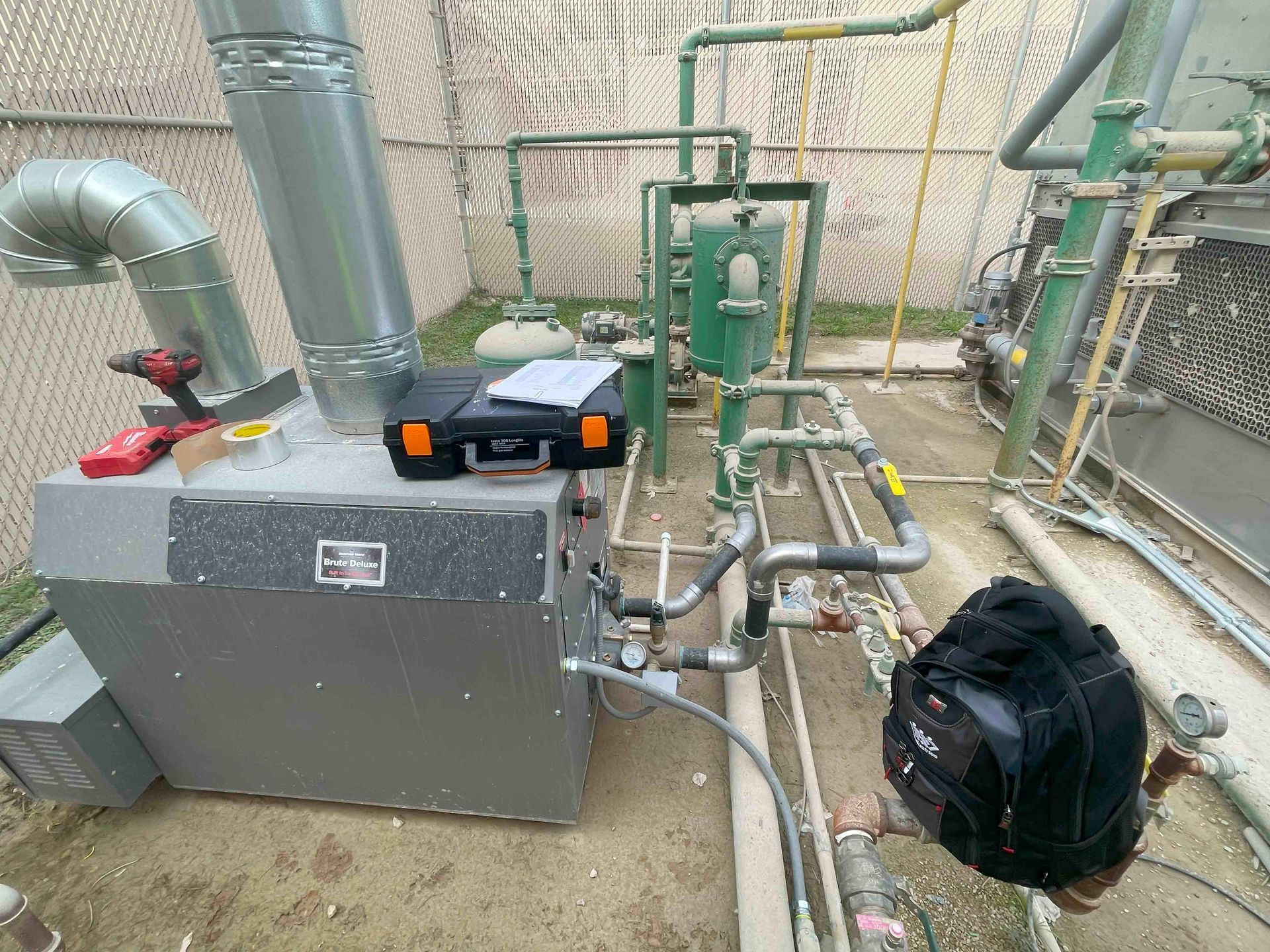 A man is working on a boiler in a factory.