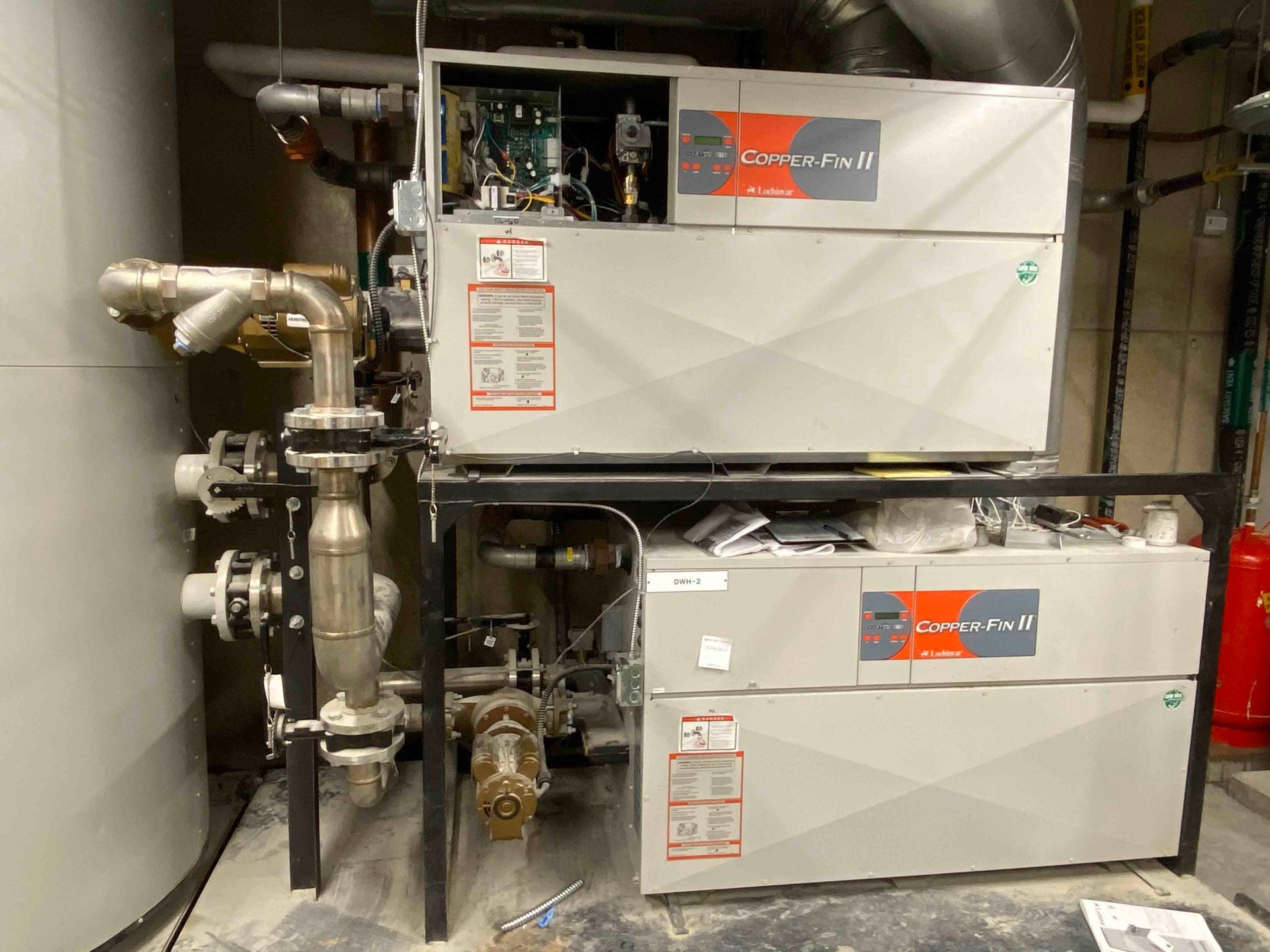 Two boilers are stacked on top of each other in a room.