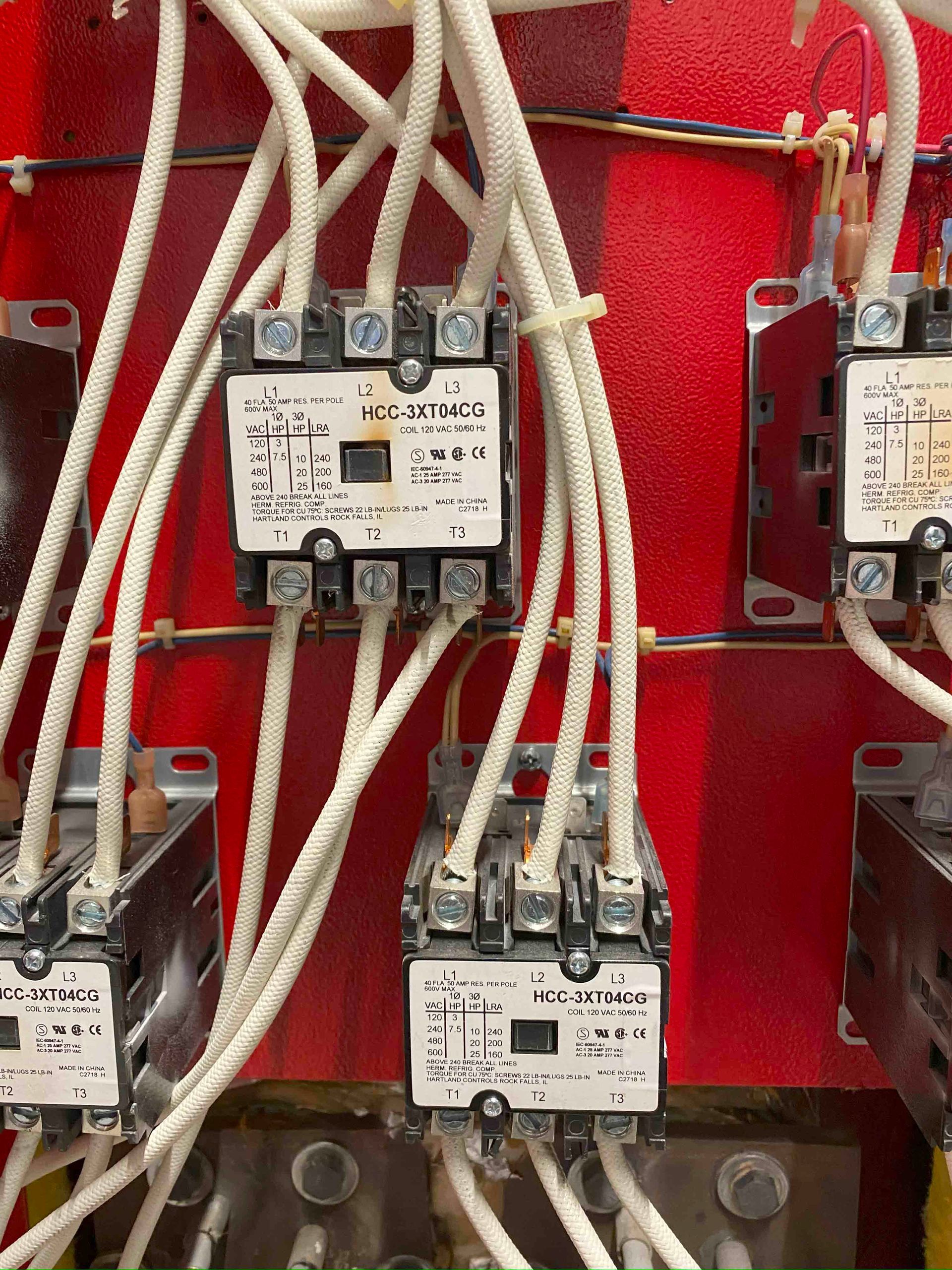 A red wall with a bunch of wires coming out of it