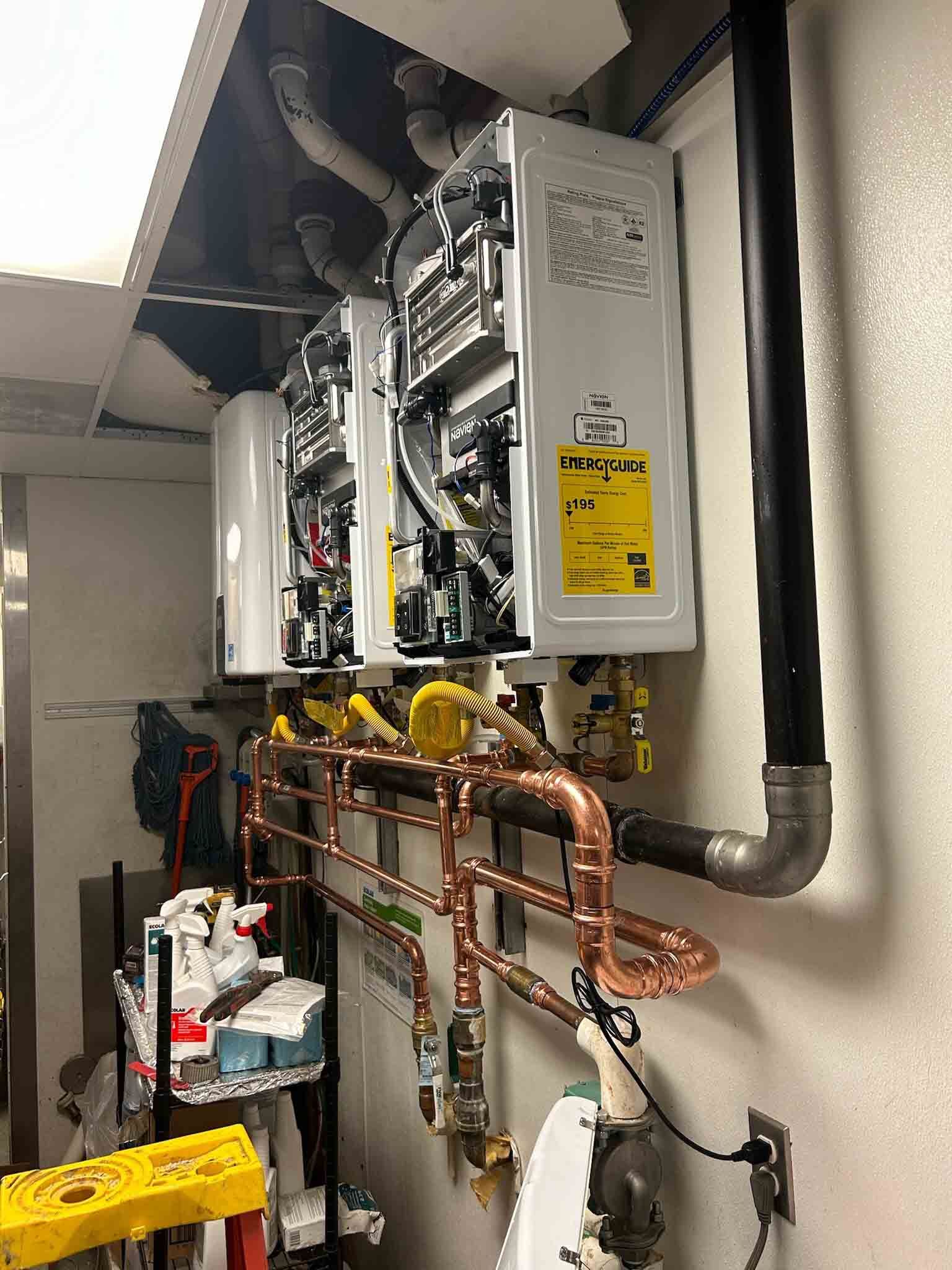 A water heater is being installed on a wall with copper pipes.