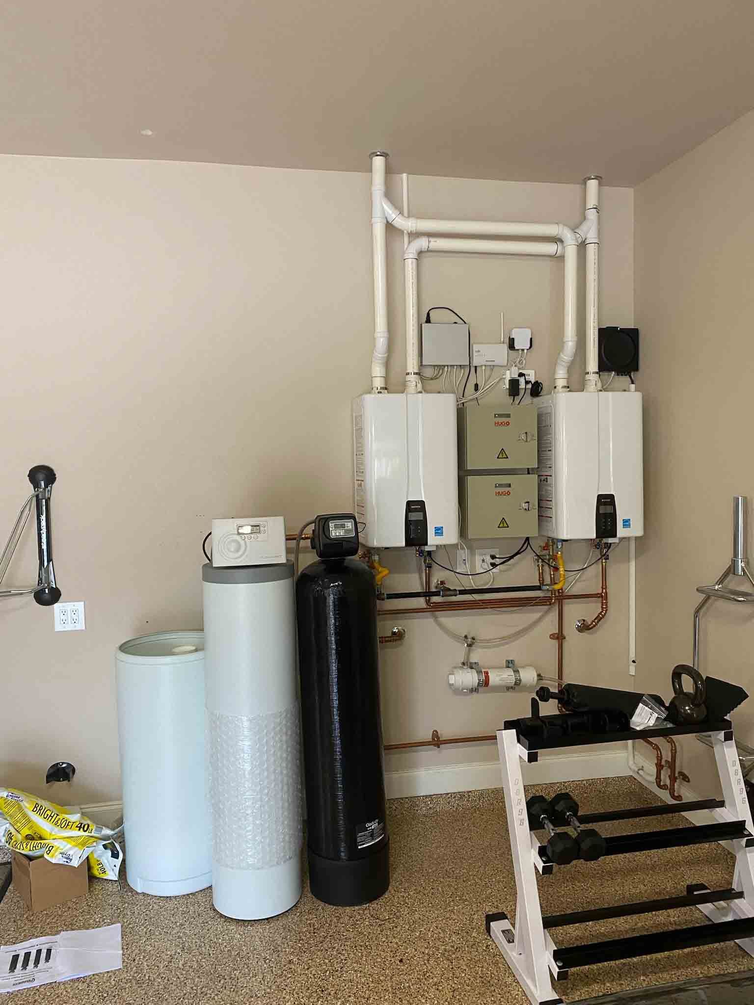 A room with a lot of pipes and a water heater.