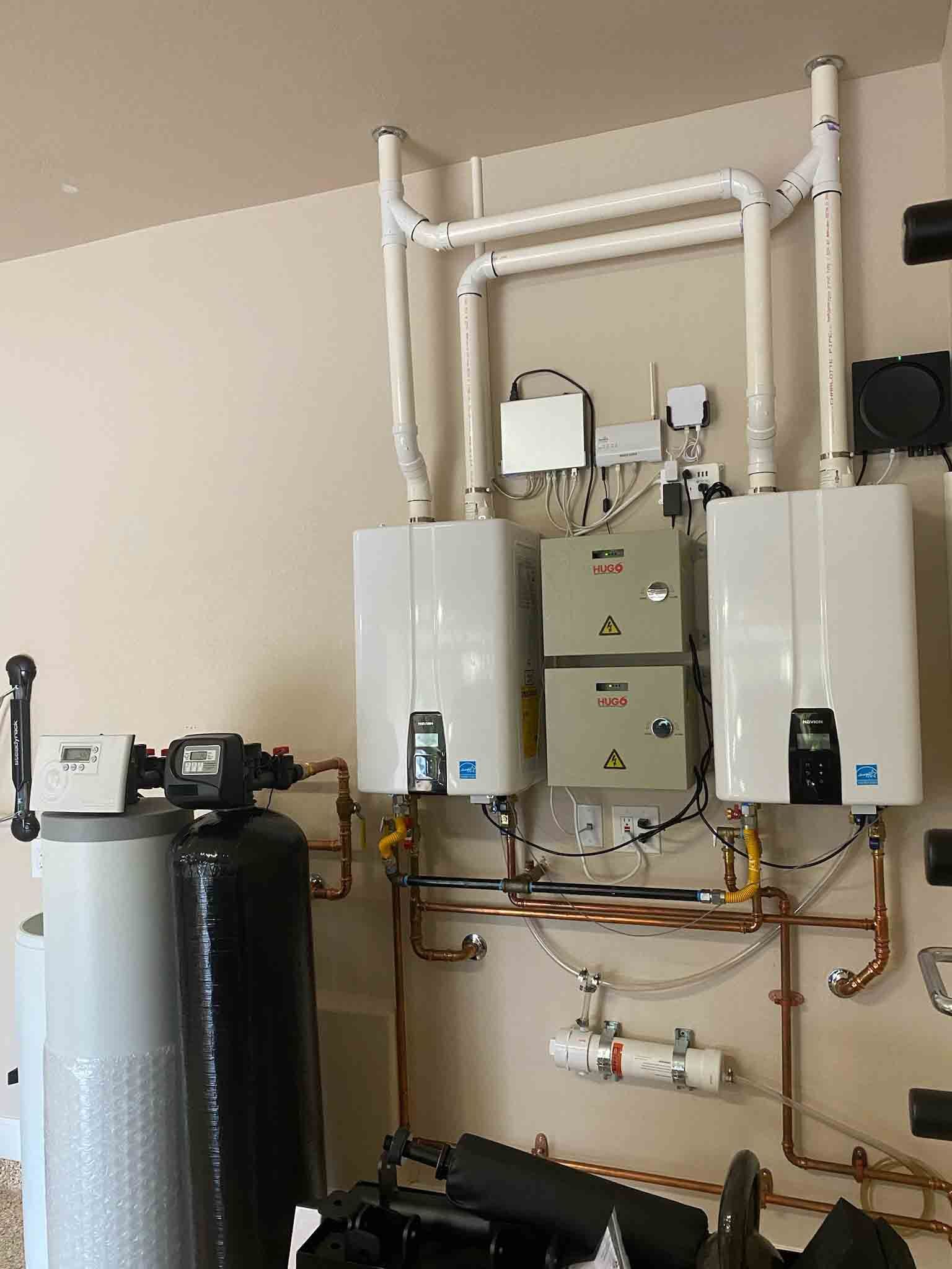 A room with two water heaters and a water filter.
