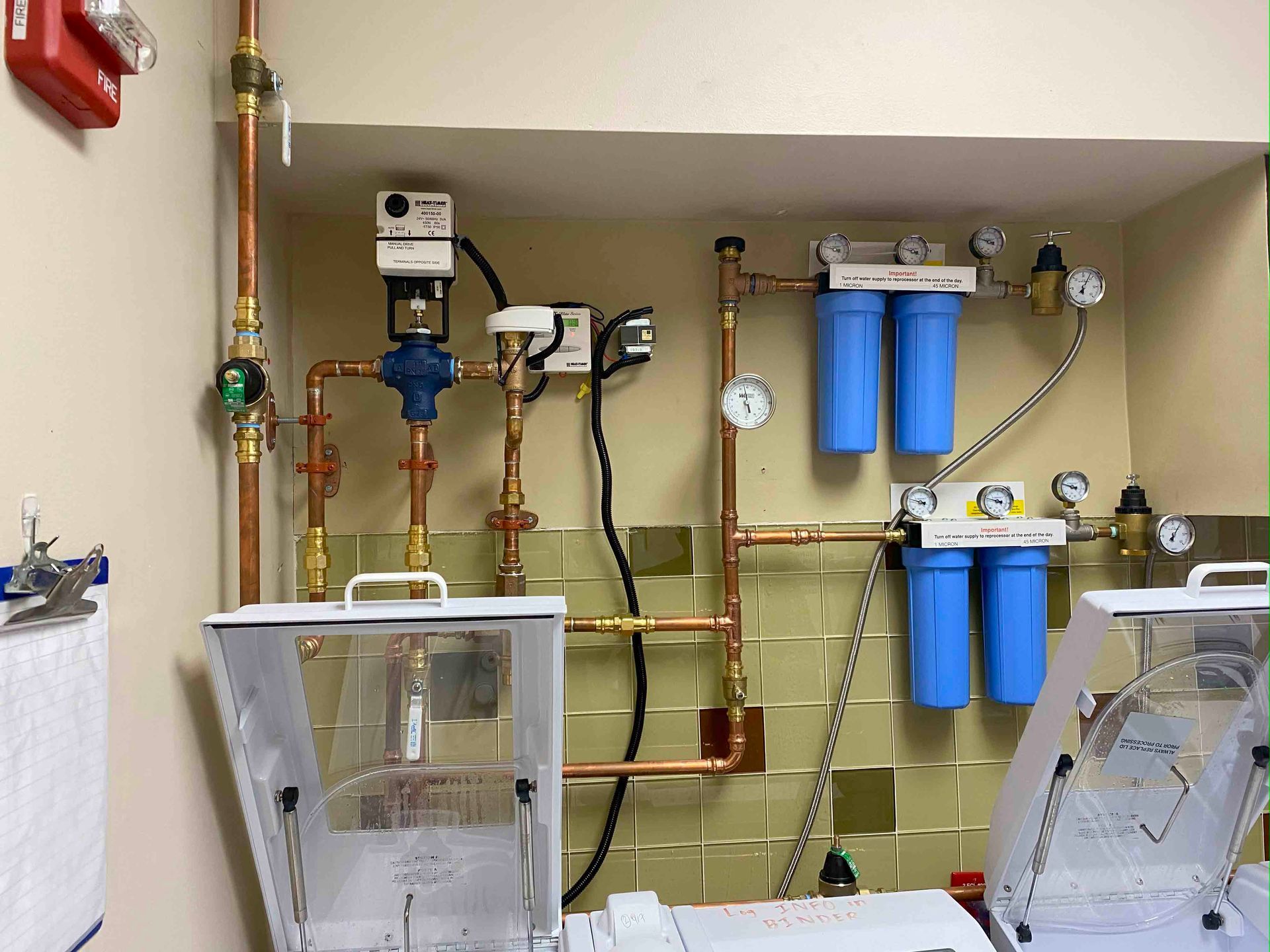 A room with a lot of pipes and gauges on the wall