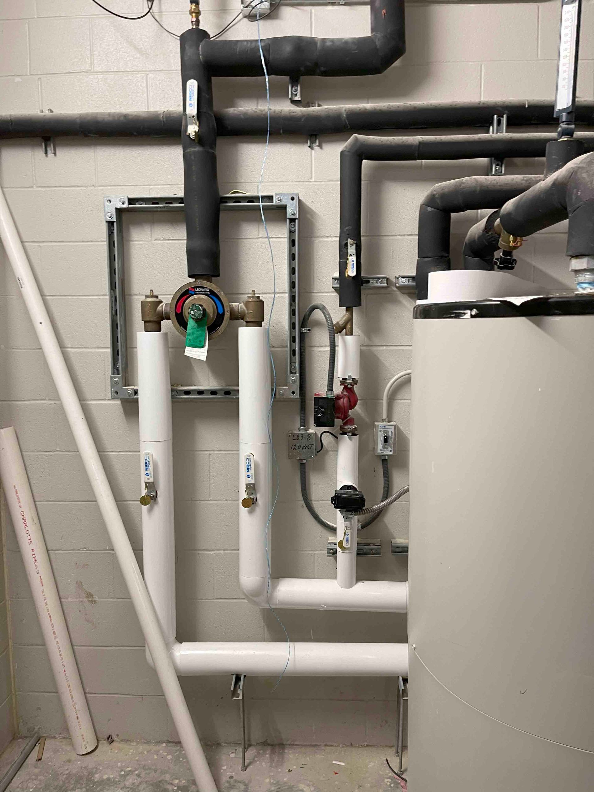 A room with a lot of pipes and valves on the wall.