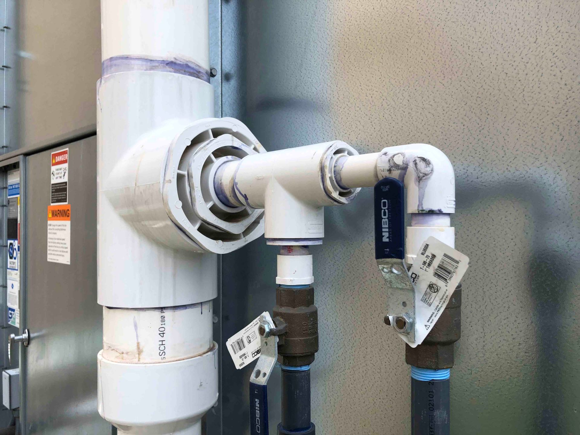 A close up of a pipe with a valve attached to it.