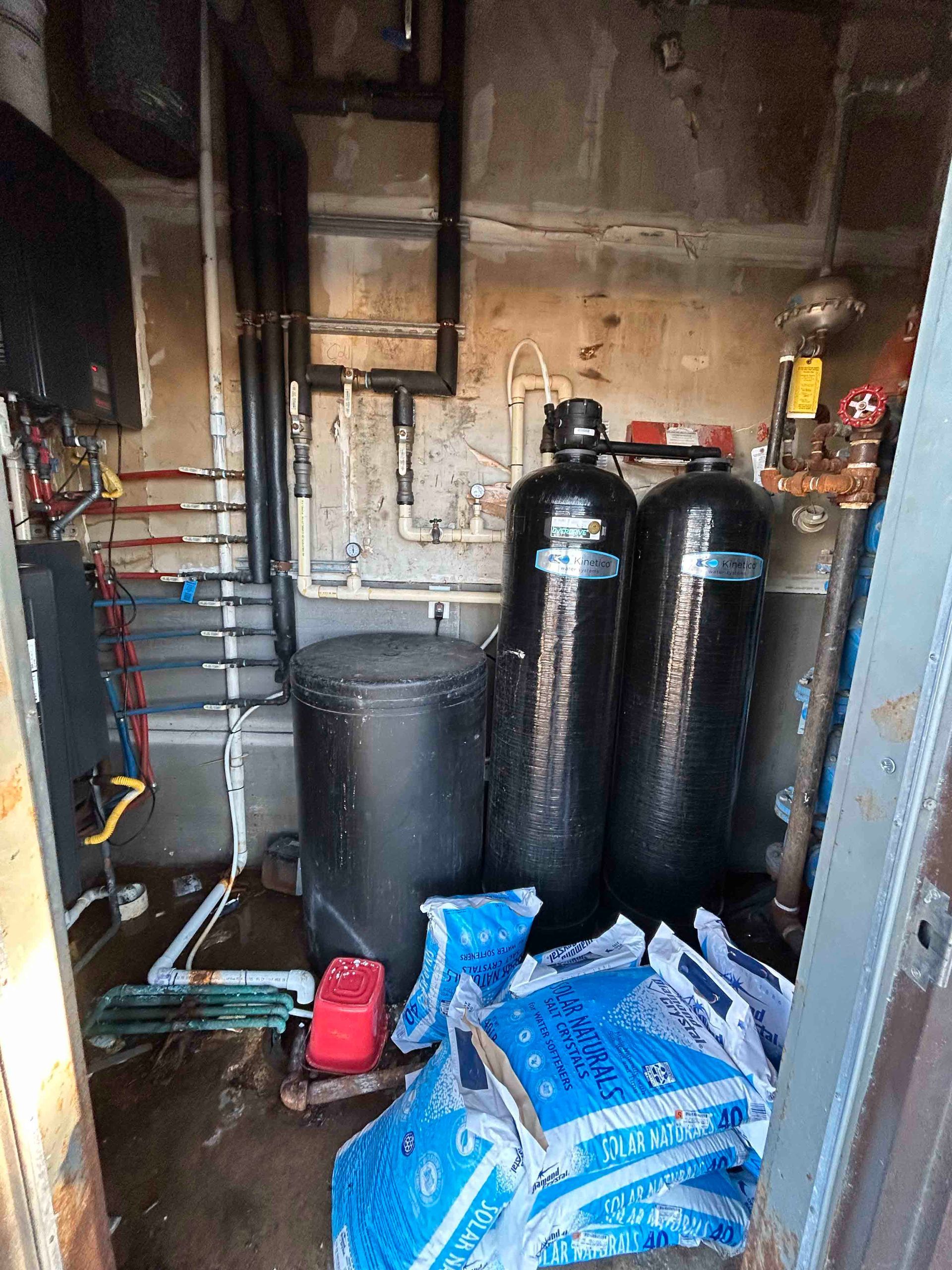 A room with a lot of pipes and tanks in it.