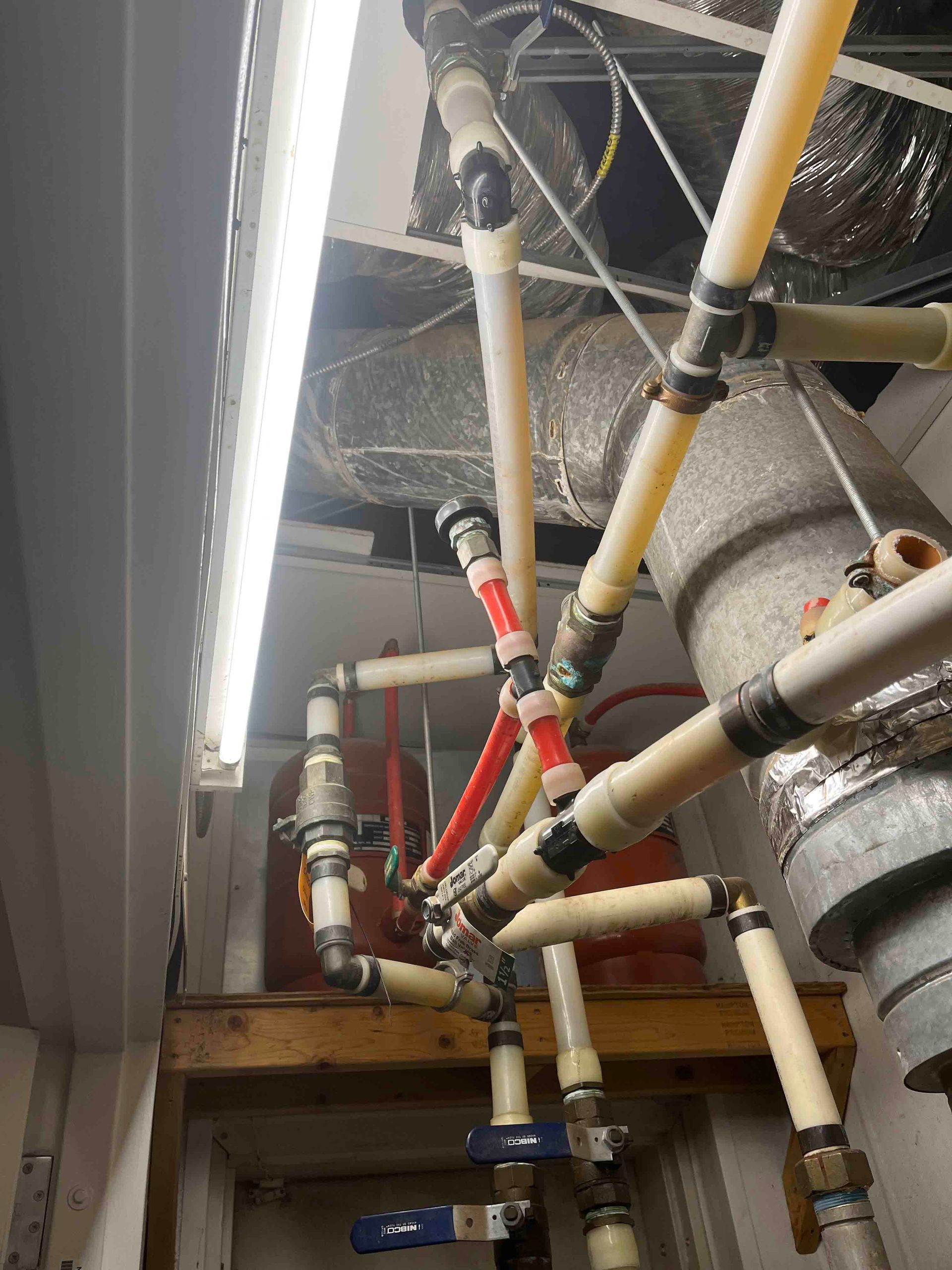 A bunch of pipes are hanging from the ceiling in a room.