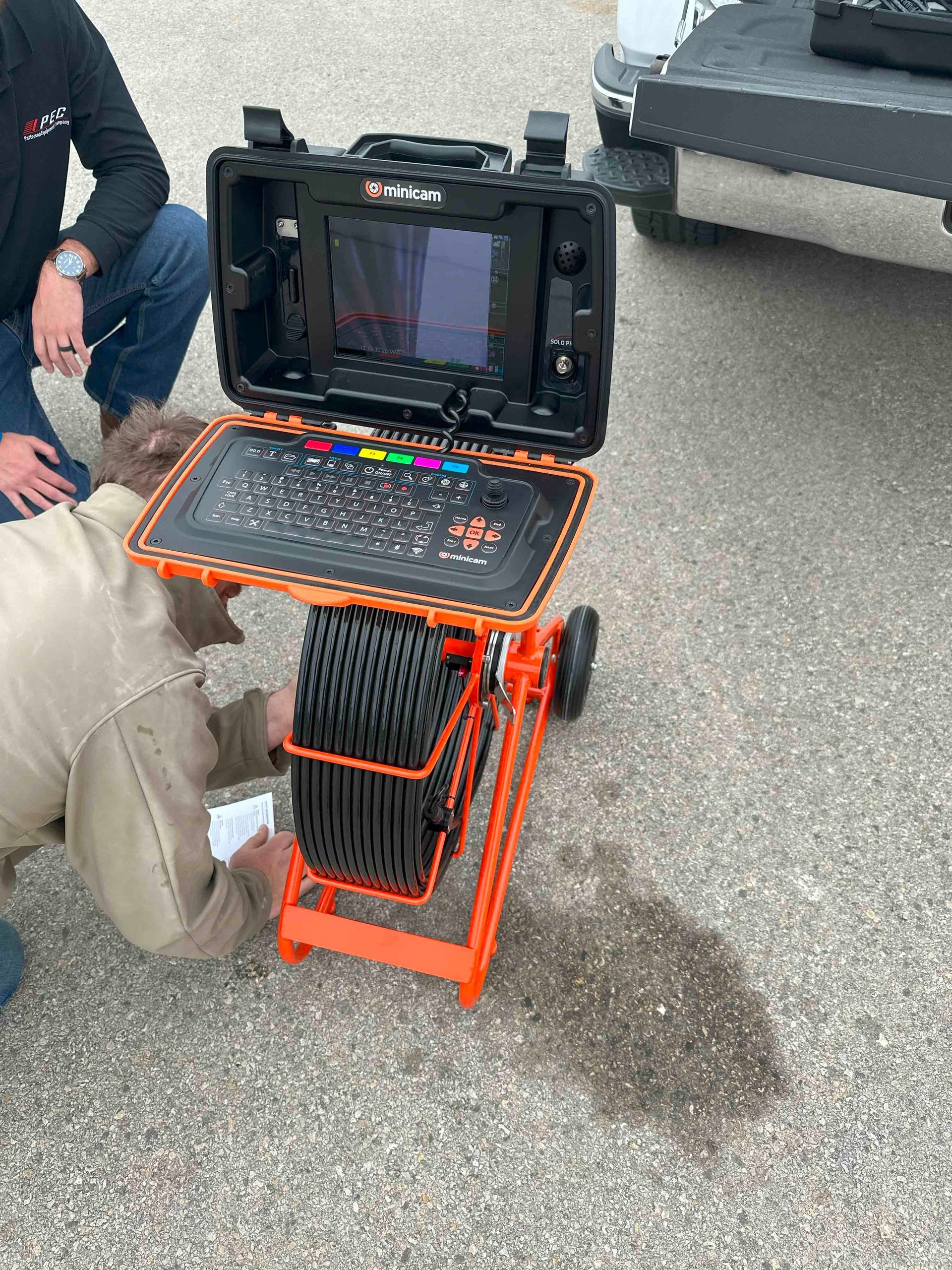A man is kneeling down next to a camera on a cart.