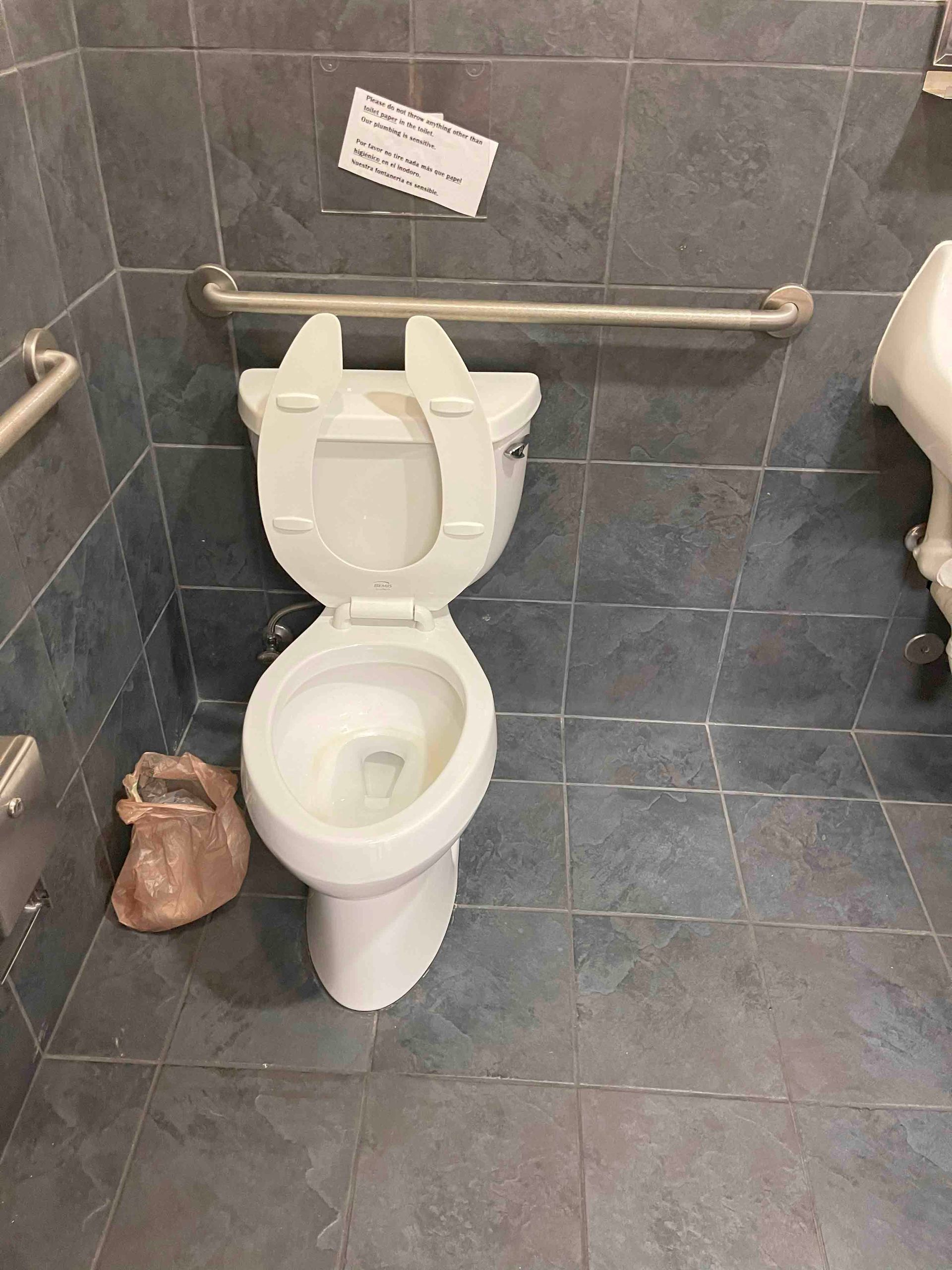 A toilet is sitting in a bathroom next to a urinal.