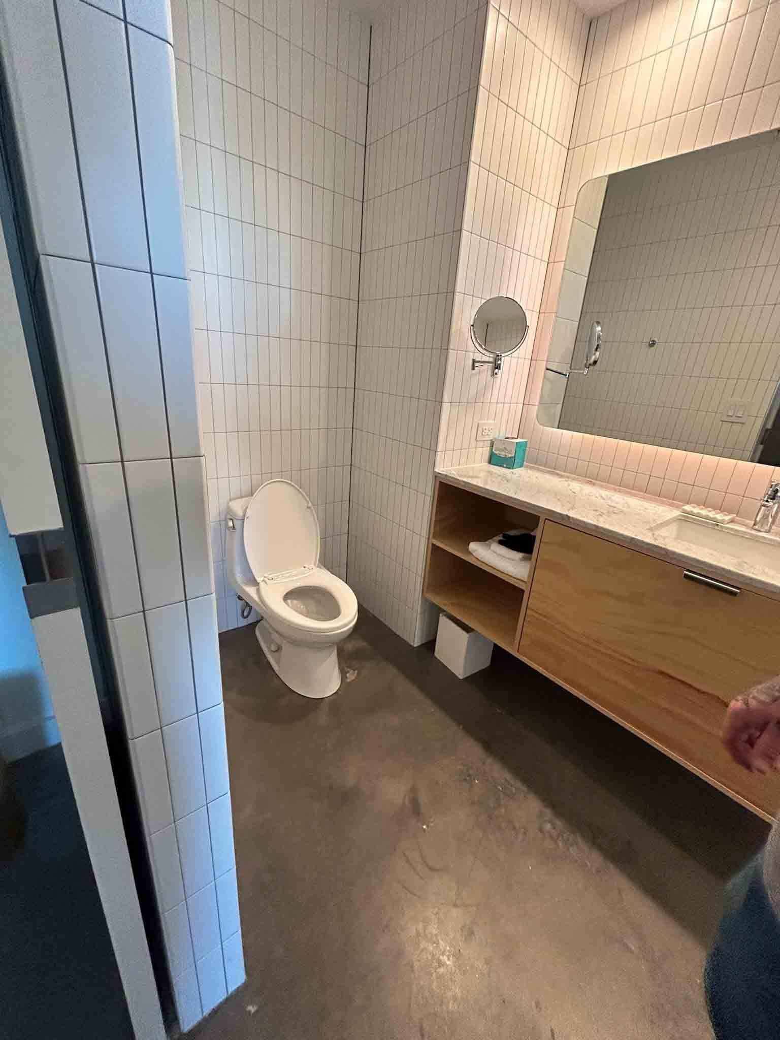 A bathroom with a toilet , sink and mirror.